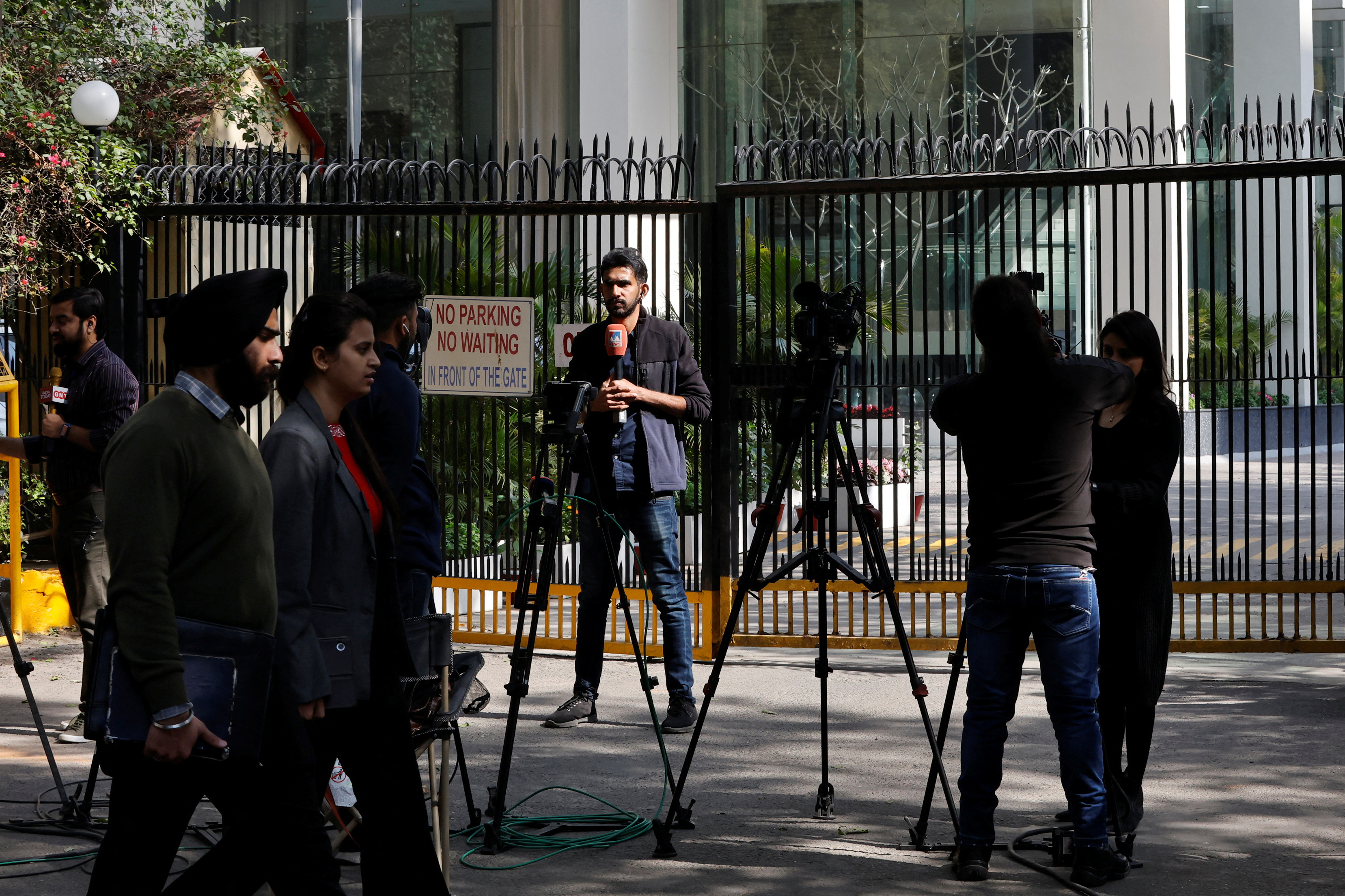 Reporters outside a New Delhi building having BBC offices, where income tax raids were conducted for a second day