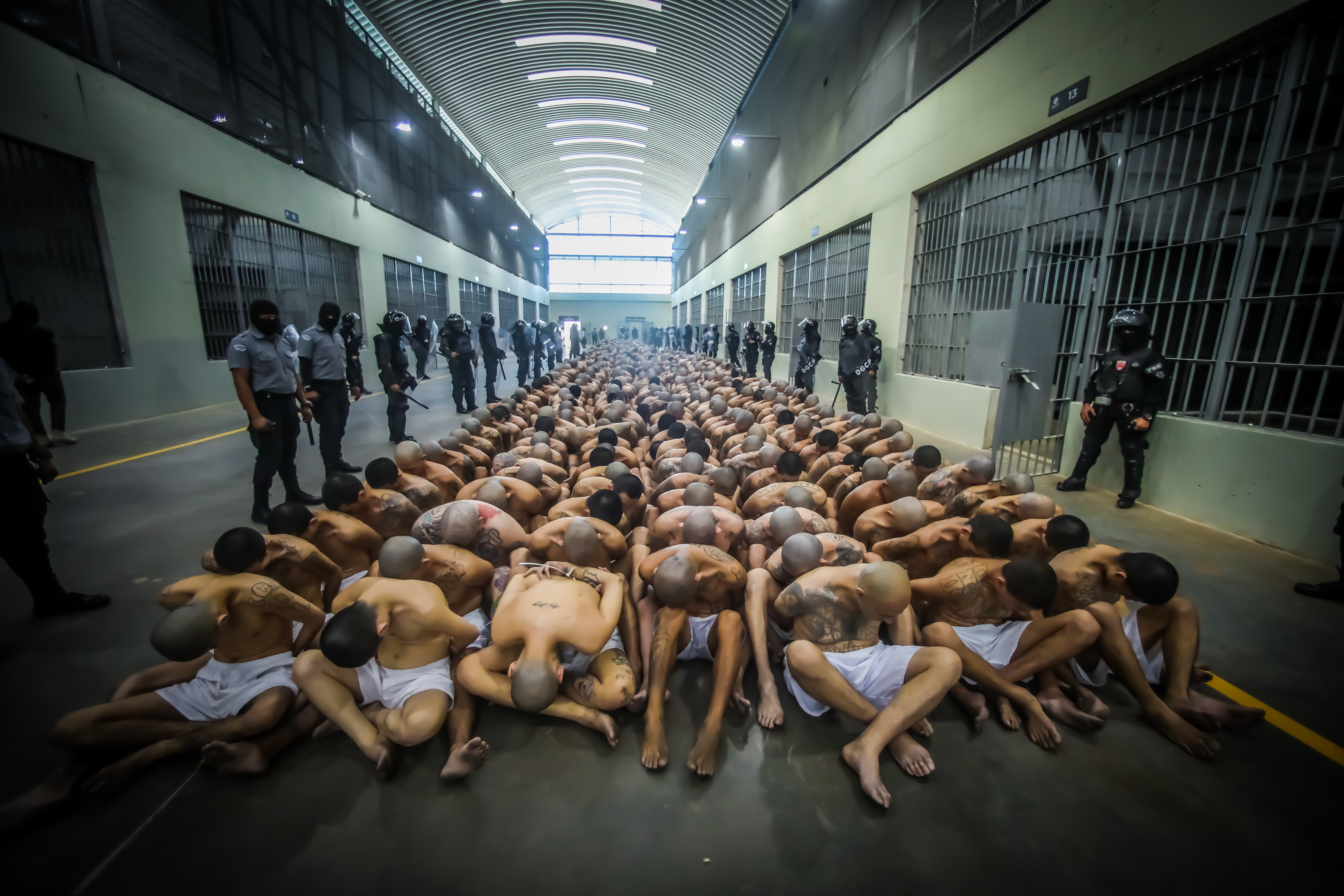 Guards watch over inmates at a prison in Tecoluca near San Salvador [Salvadoran Presidency via AFP]
