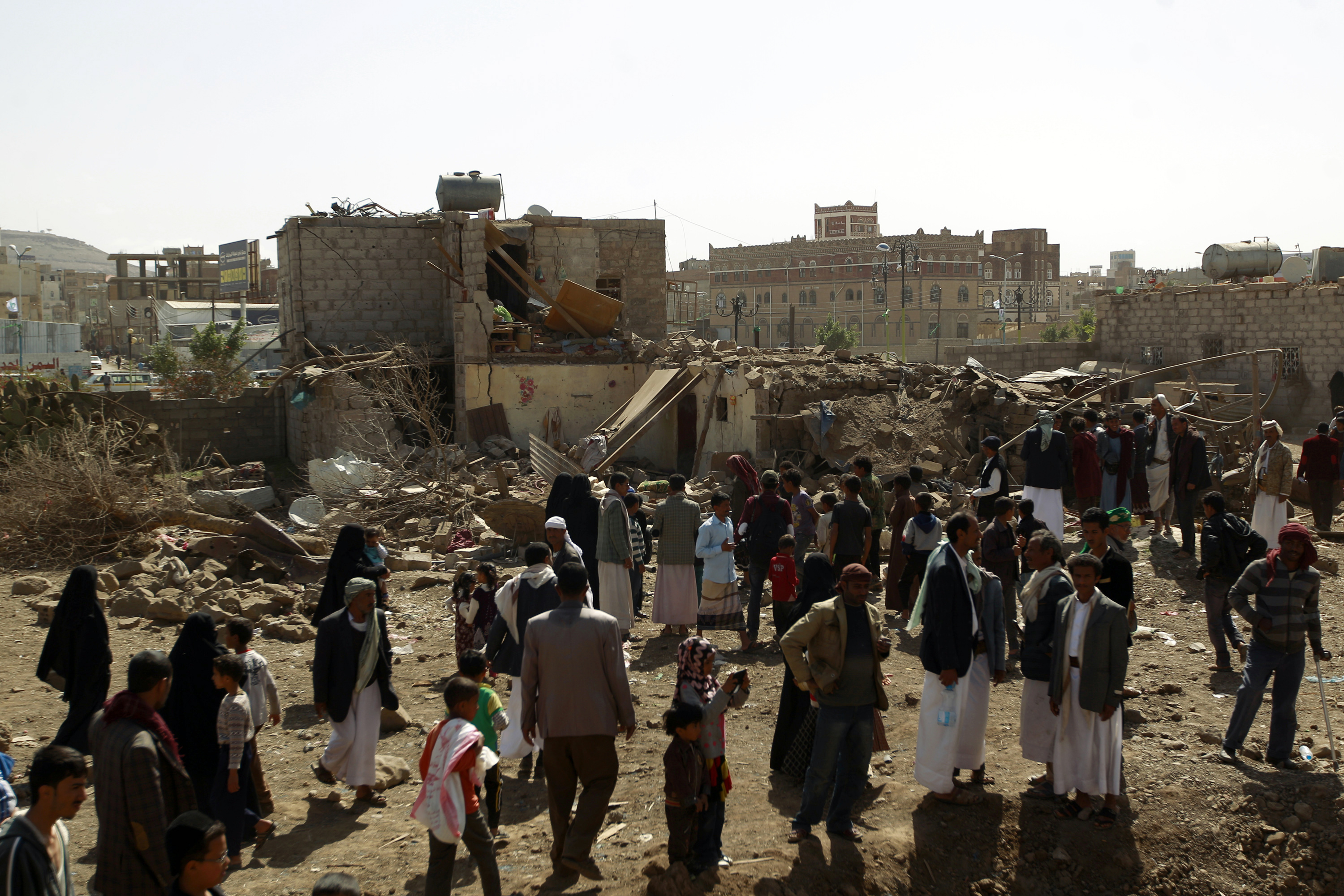 Yemenis walk past the ruins of buildings destroyed in an air raid by the Saudi-led coalition on February 25, 2016, in Sanaa