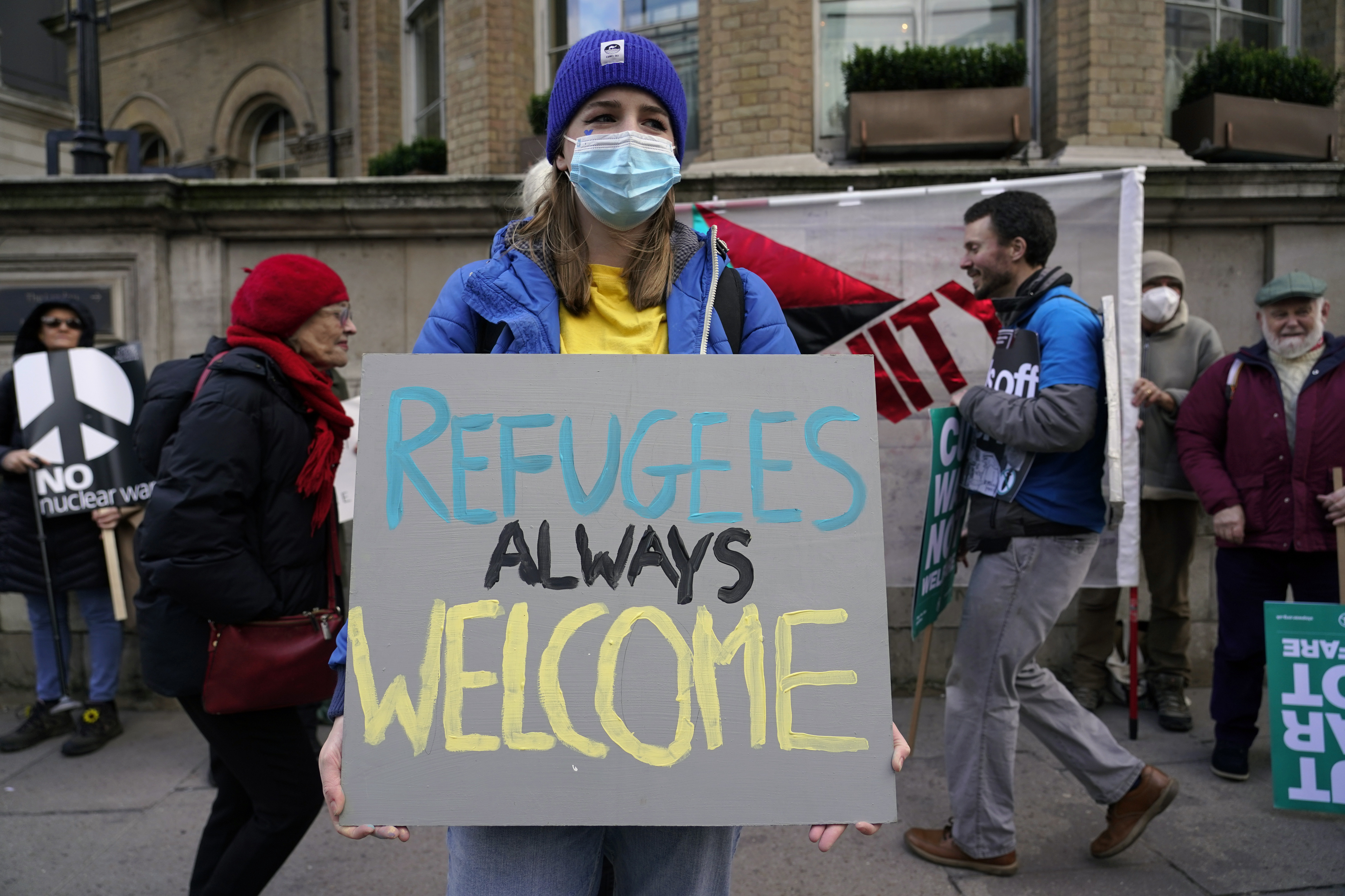 A demonstrator holds a placard saying ‘Refugees always welcome’ during an anti-war march, in London, on March 6, 2022