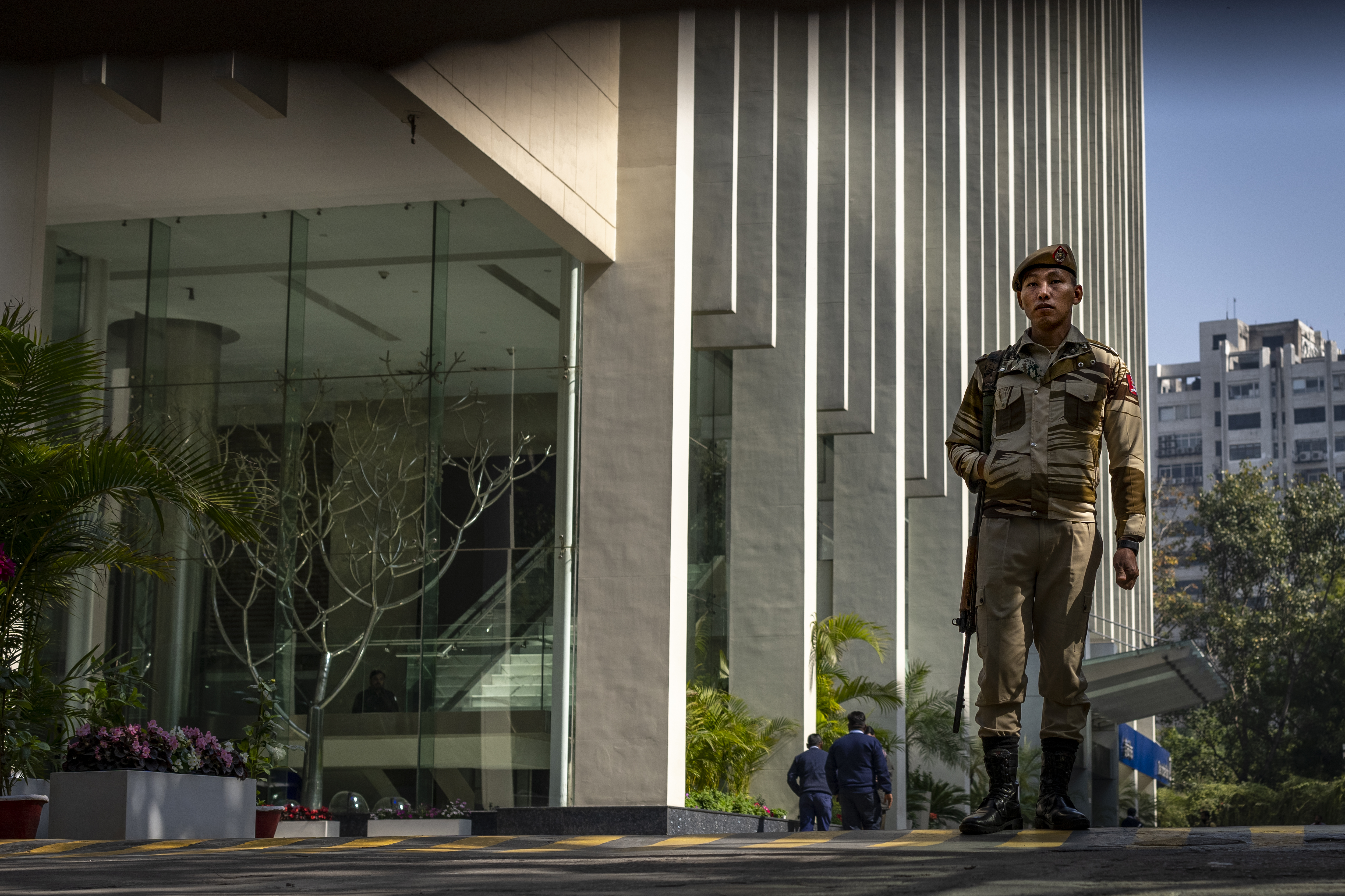 An armed security person at the gate of a building housing BBC office in New Delhi