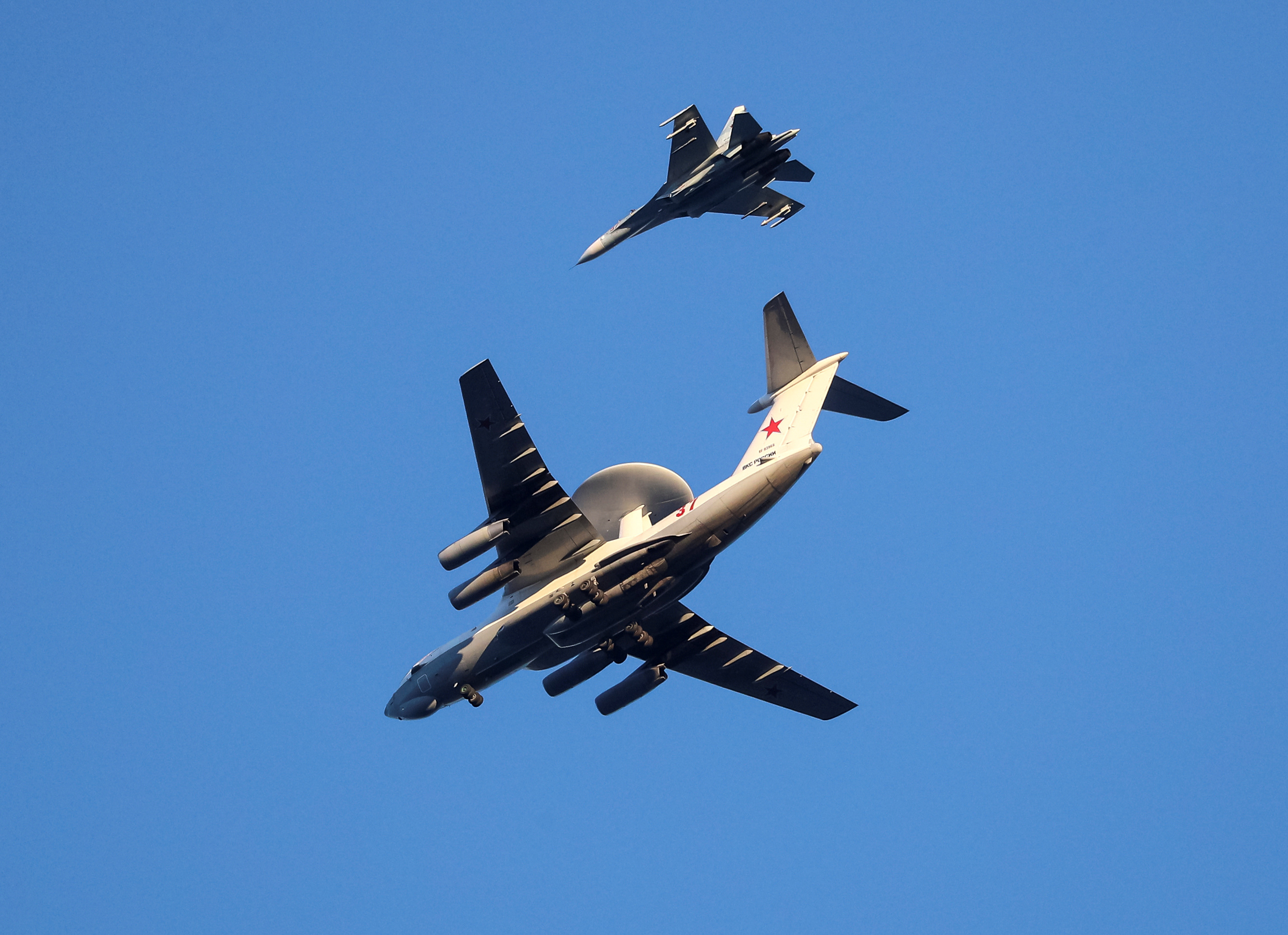 Russian Air Force Beriev A-50 early warning aircraft and Sukhoi Su-27 jet fighter fly