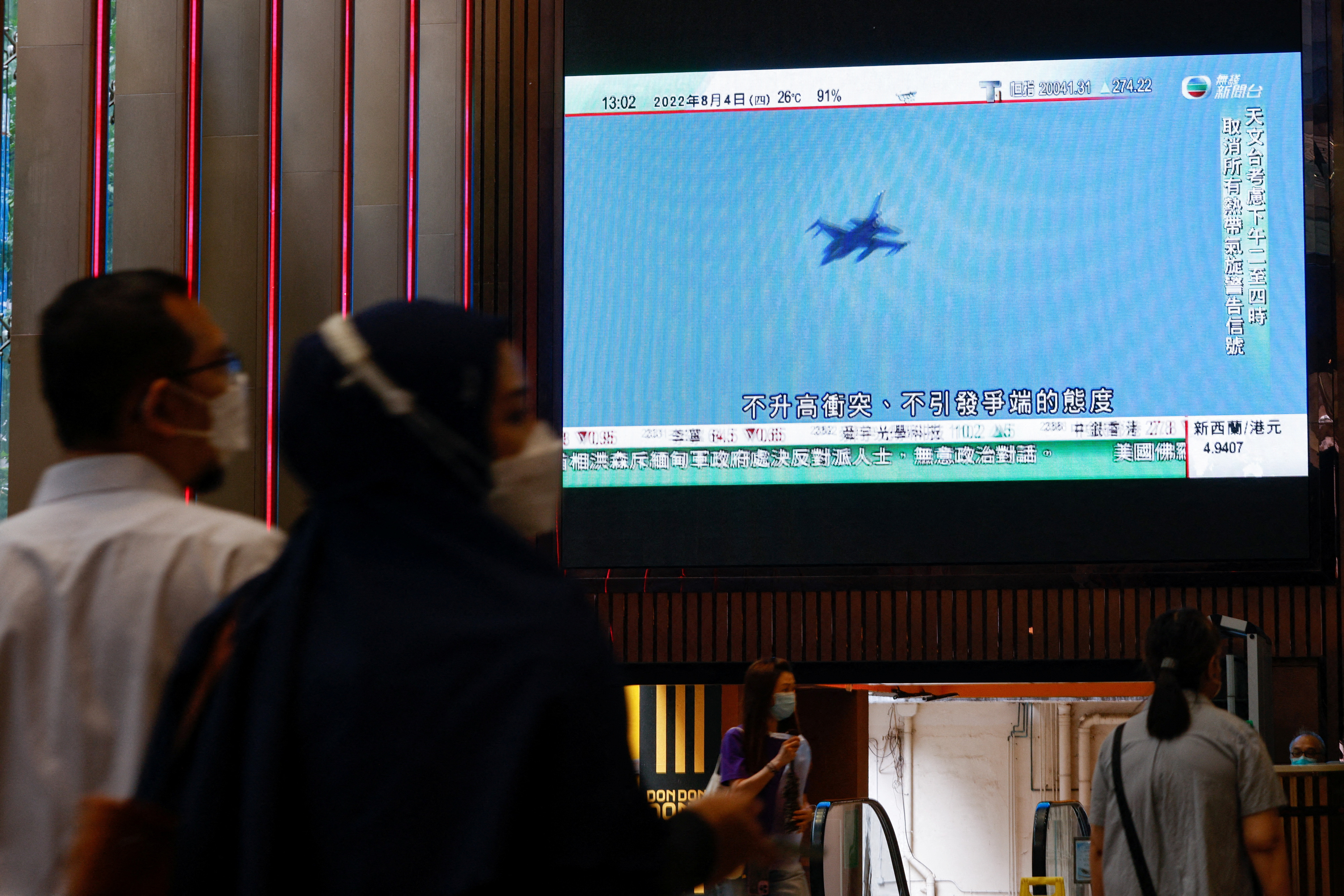 A TV screen shows that China's People's Liberation Army has begun military exercises including live firing on the waters and in the airspace surrounding the island of Taiwan, as reported by Chinese state television, in Hong Kong, China August 4, 2022. REUTERS/Tyrone Siu