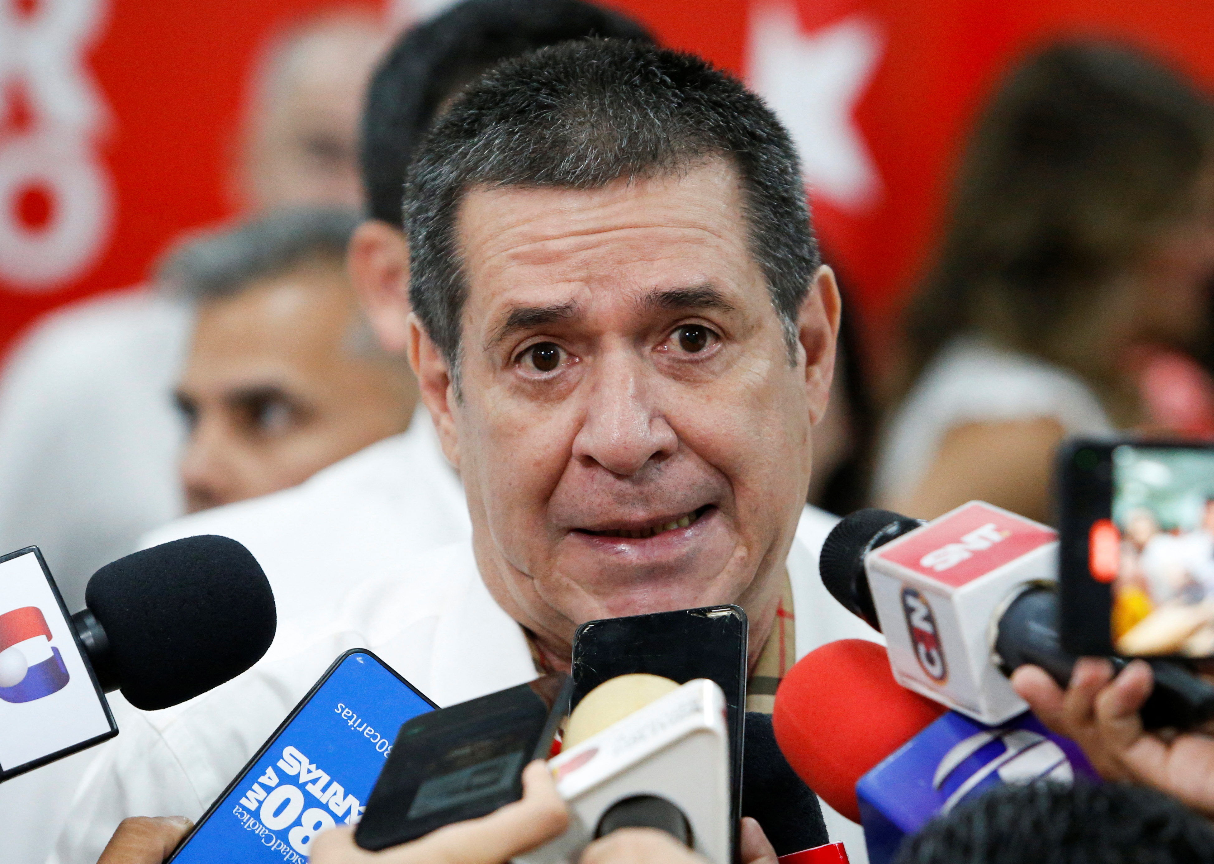 A man speaks into a multiple microphones pointed at his face