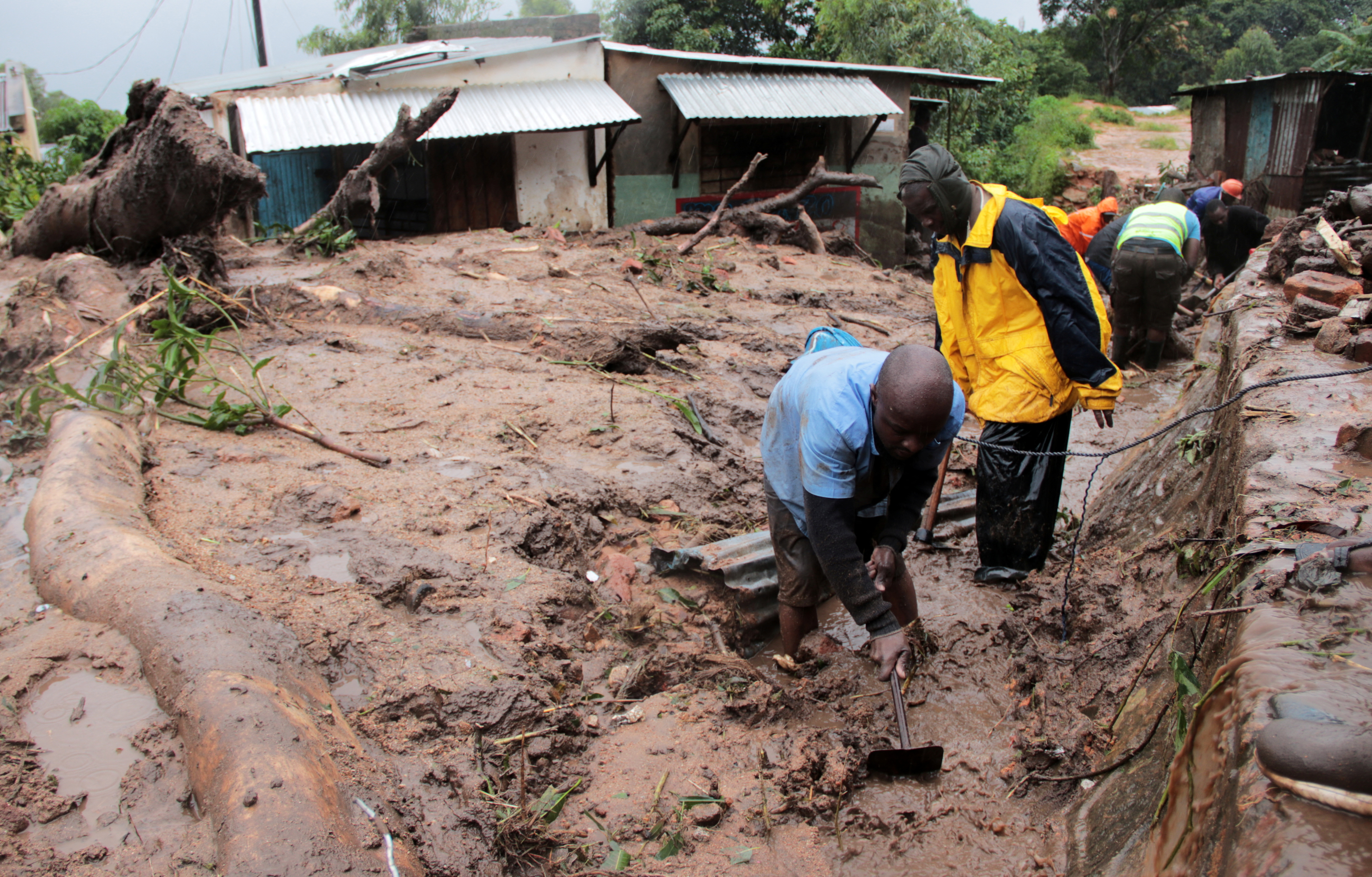 Men dig in search of survivors and victims in the mud and debris left by Cyclone Freddy in Chilobwe, Blantyre, Malawi