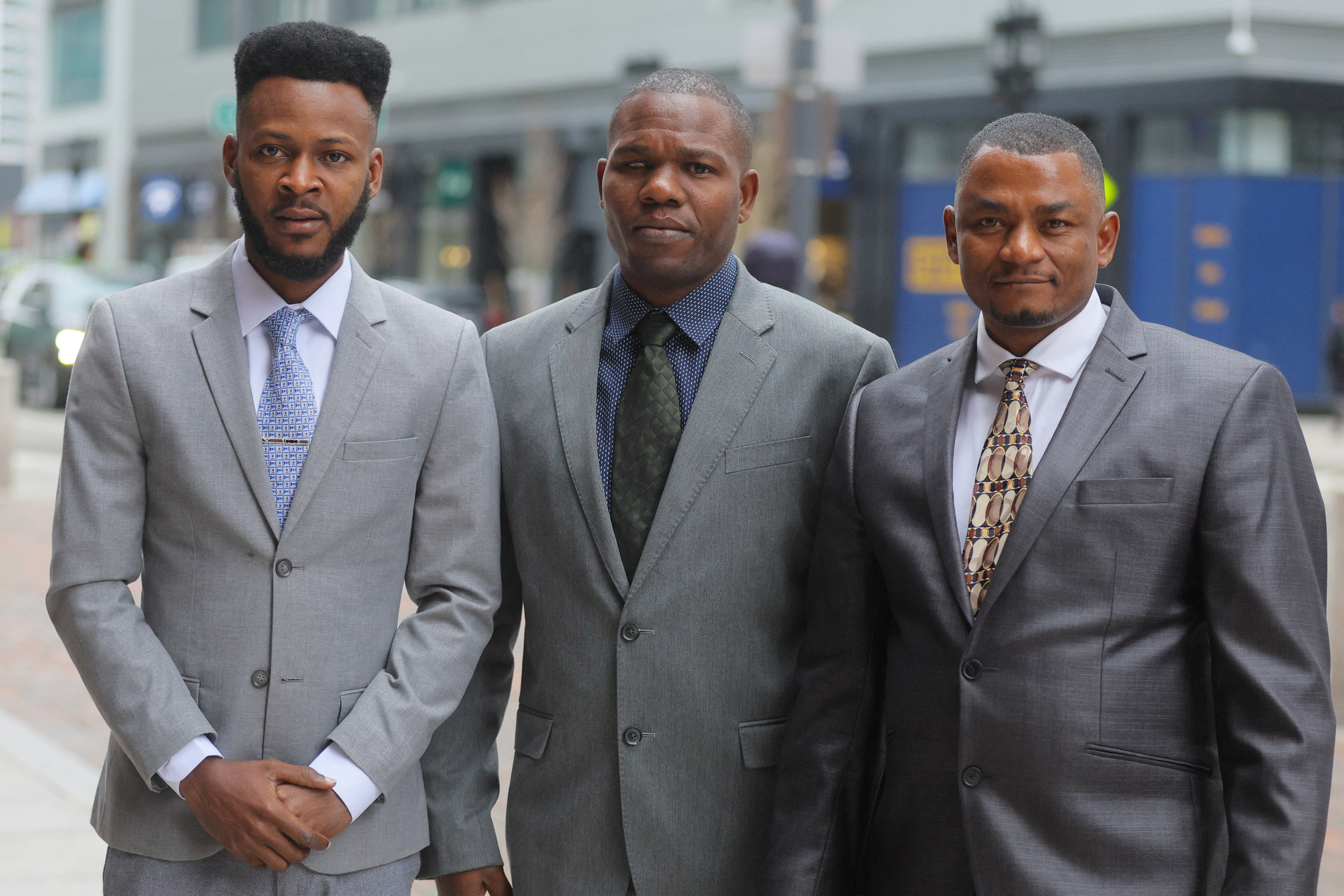 Three men, side by side, in suits