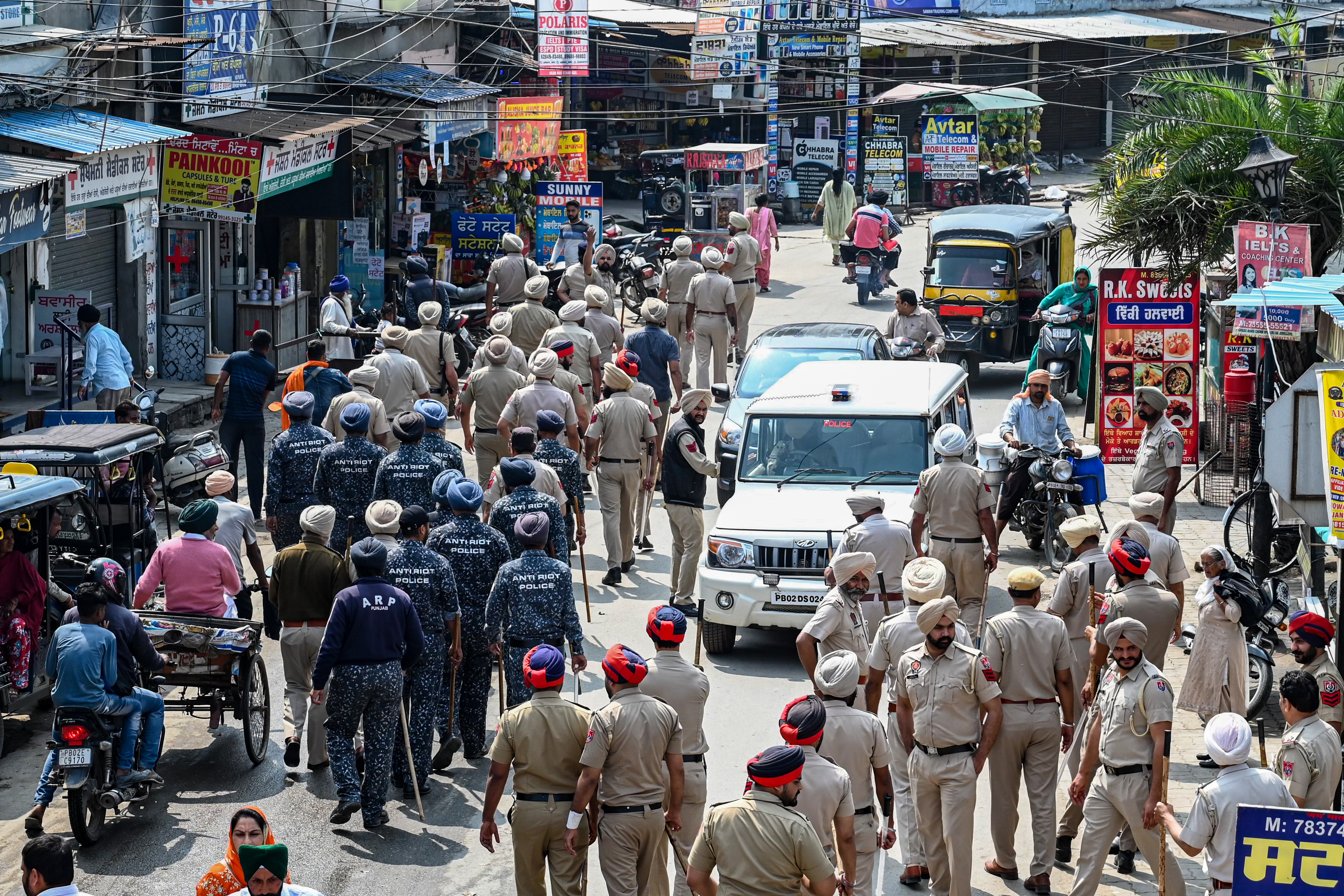 Police and security personnel patrol a village near Amritsar in India’s Punjab state