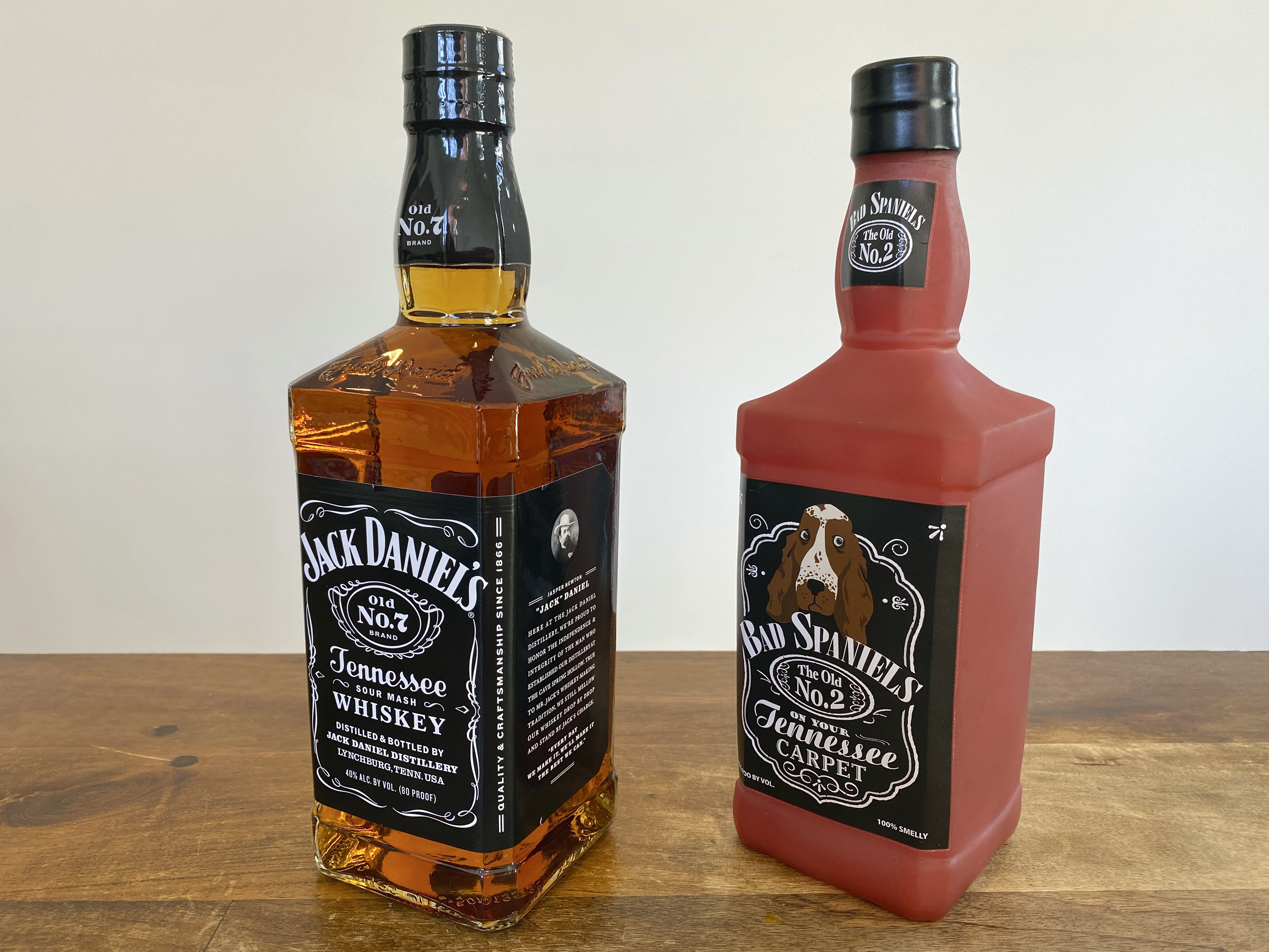 A bottle of Jack Daniels Tennessee Whiskey next to a Bad Spaniels dog toy