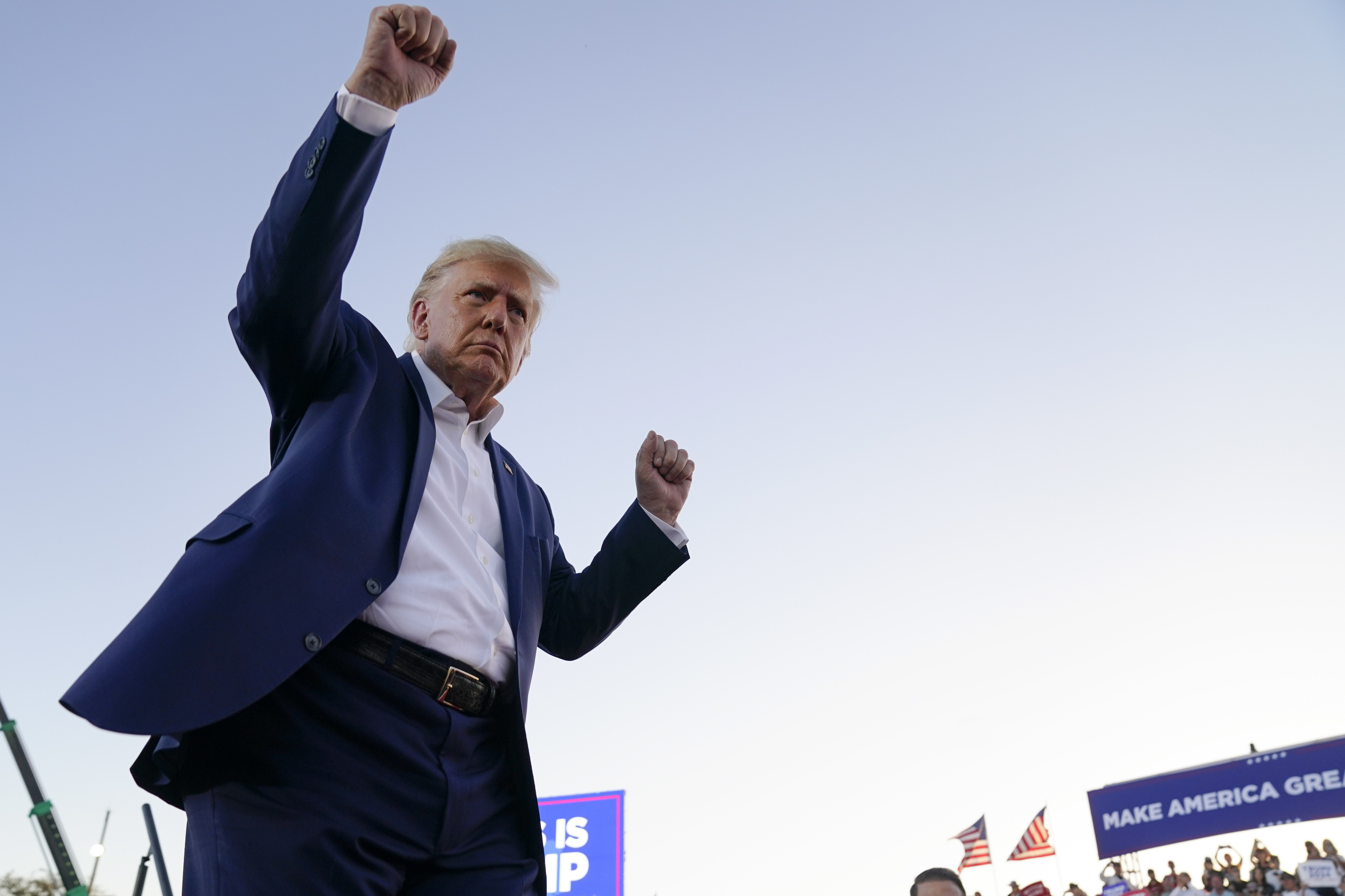 Former President Donald Trump dances with his arms raised during a campaign rally after speaking at Waco Regional Airport.