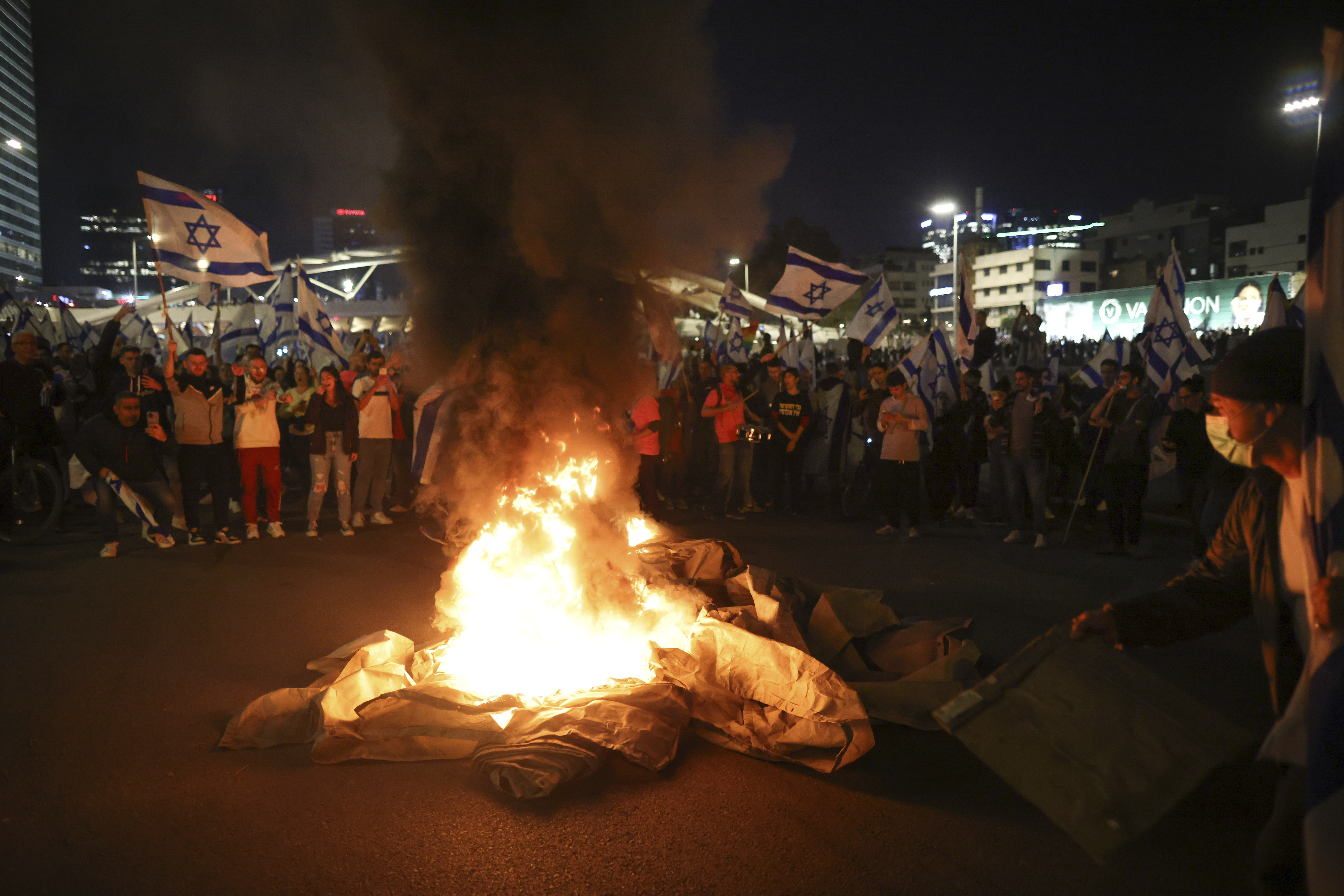 Israelis opposed to the judicial amendments set up bonfires and block a highway during a protest moments after Netanyahu fired his defence minister, in Tel Aviv, on March 26, 2023