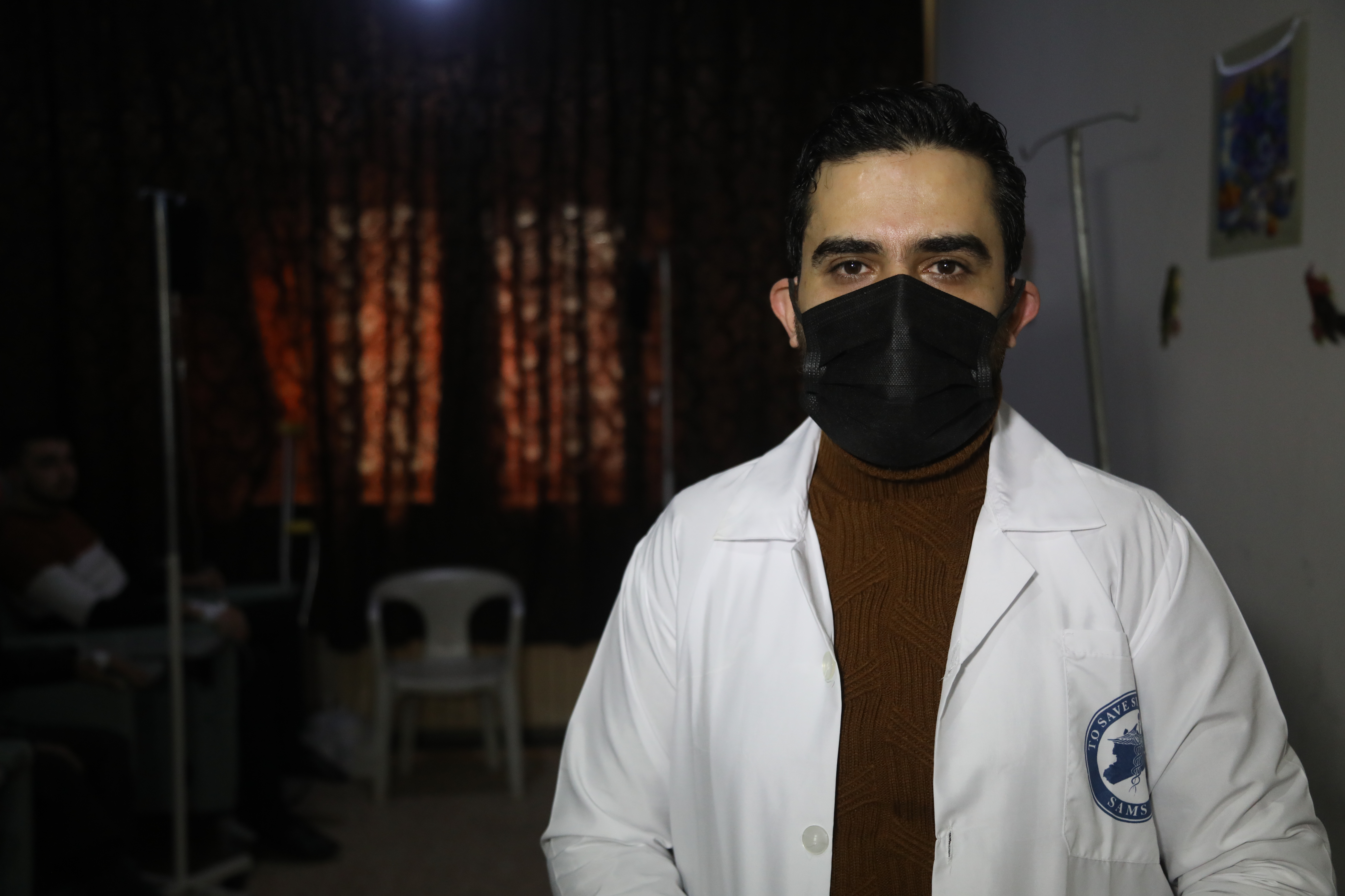 Dr Jamo, wearing a black face mask and white coat