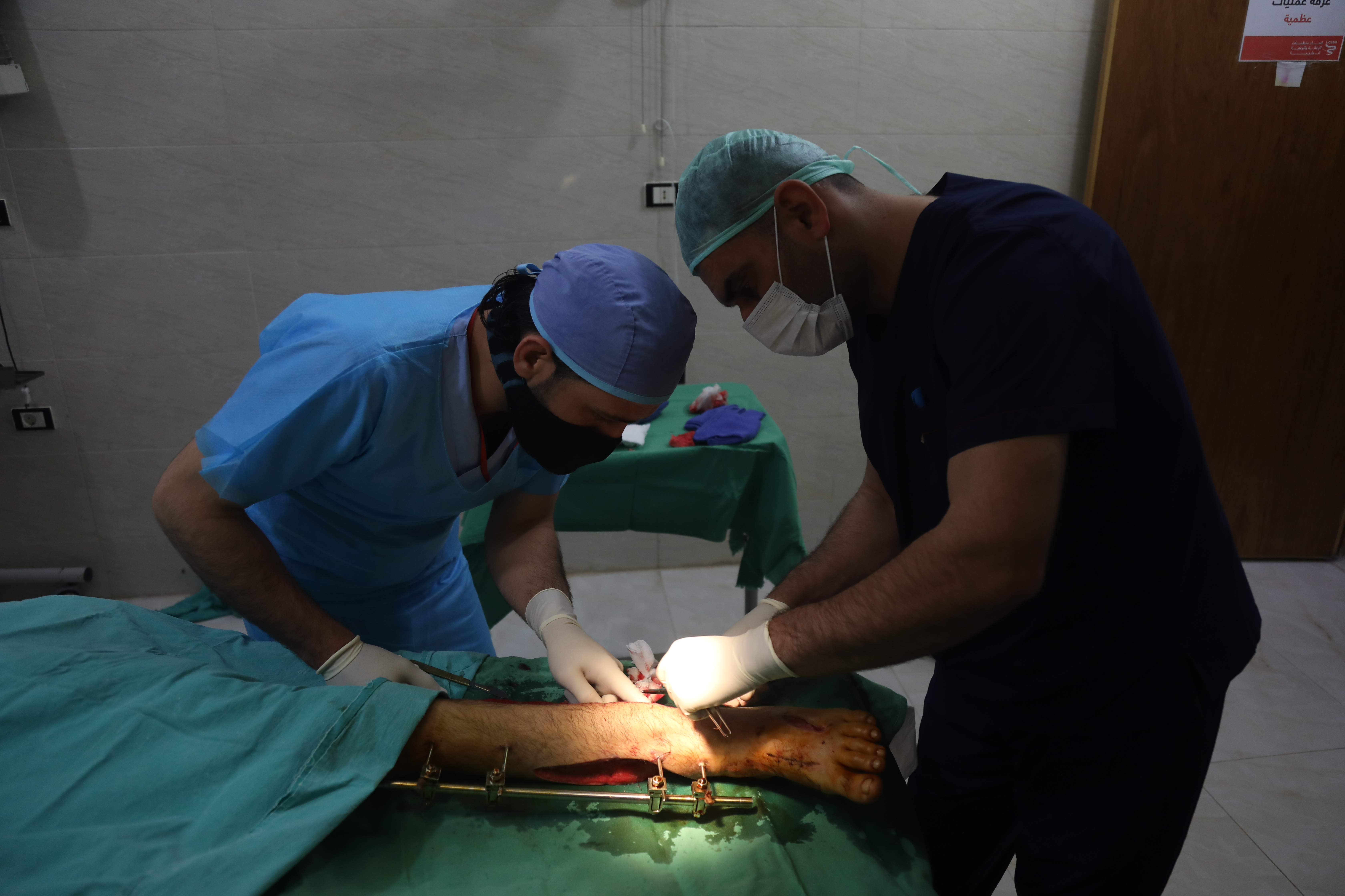 Doctor Abdelsalam al-Naasan, right, an orthopaedic surgeon at Akrabat Hospital in Idlib, operating on a patient