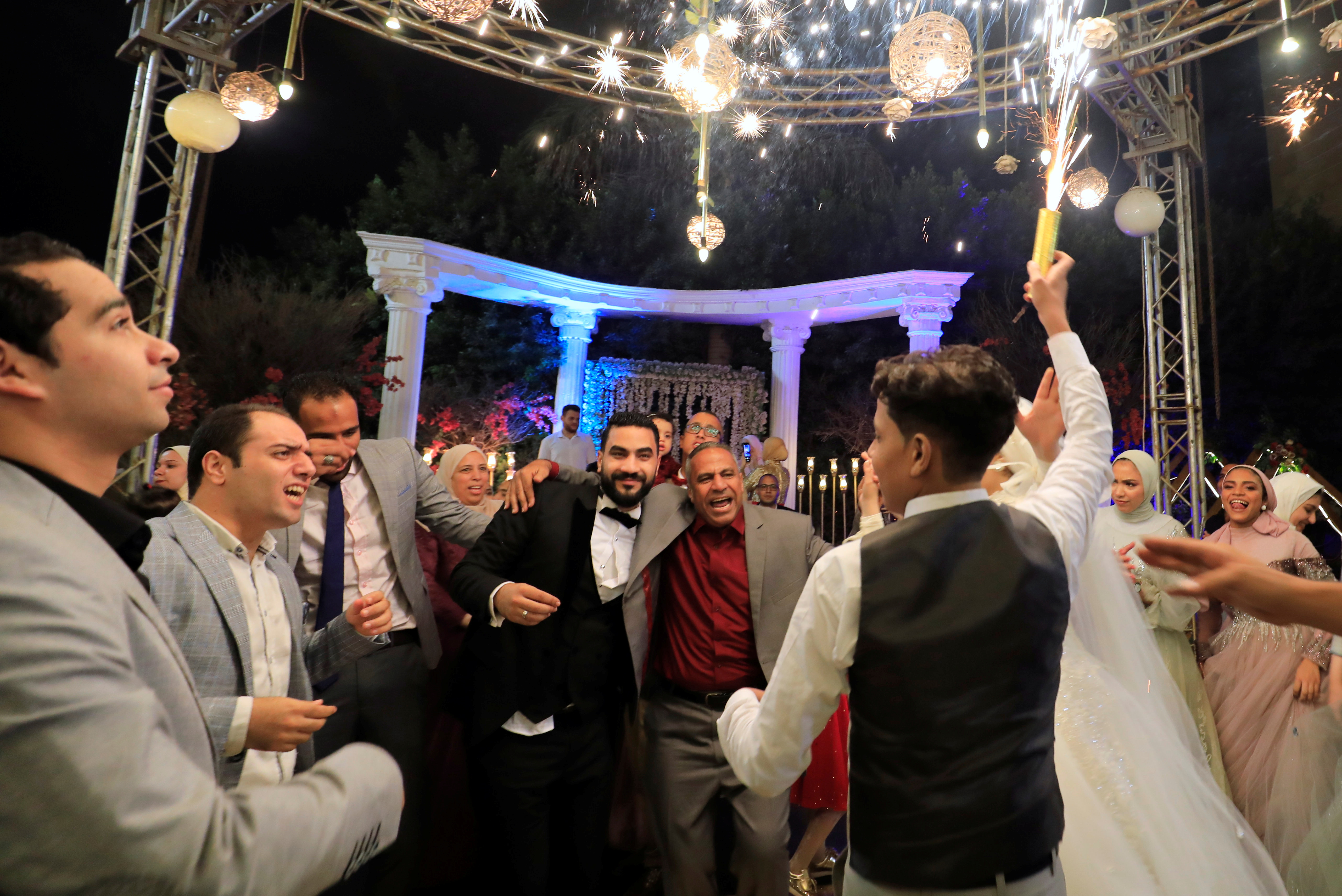 A groom dances with his father and guests at his wedding in Quwesna, Menoufia