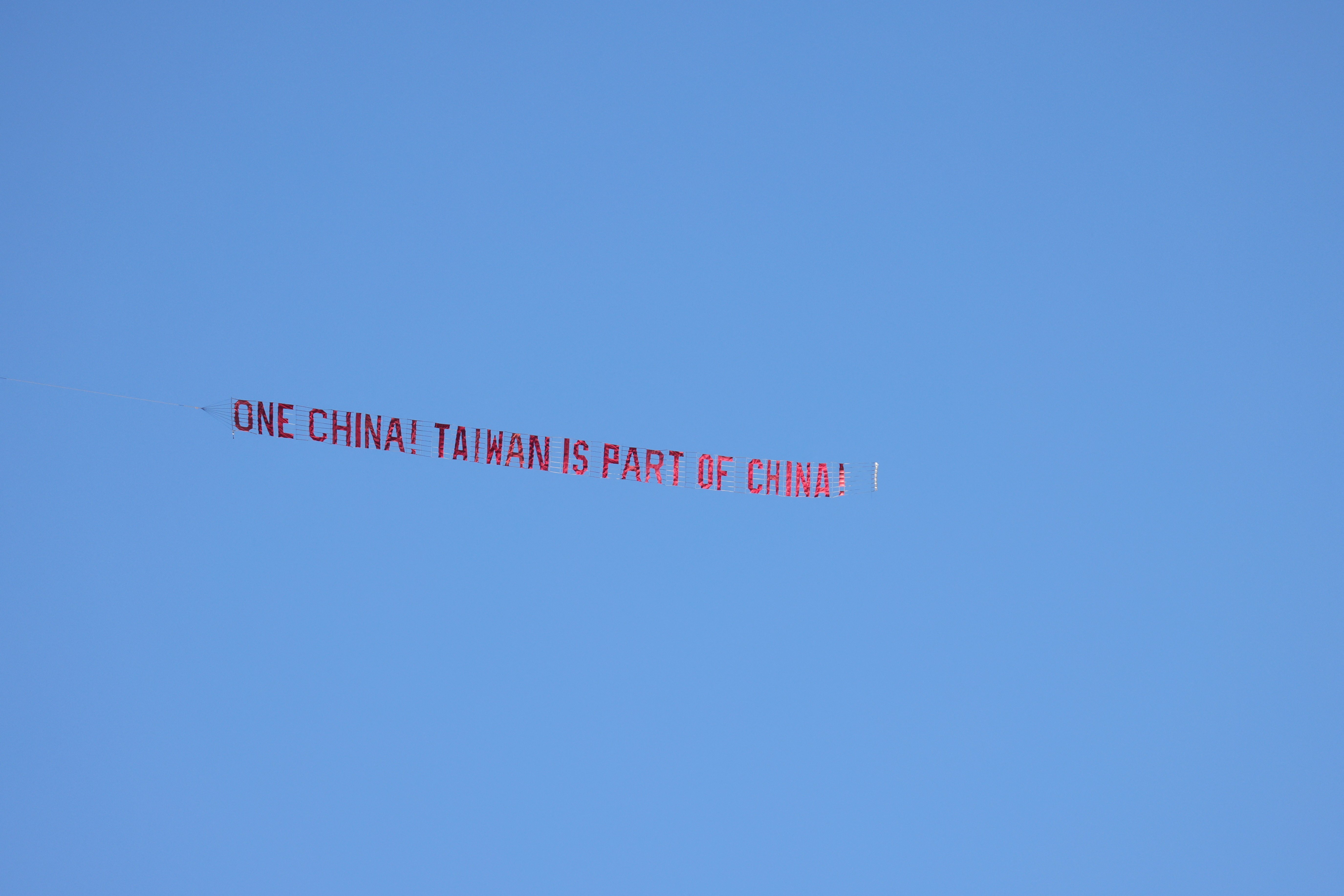 An airplane pulls a banner that reads "One China! Taiwan is part of China."