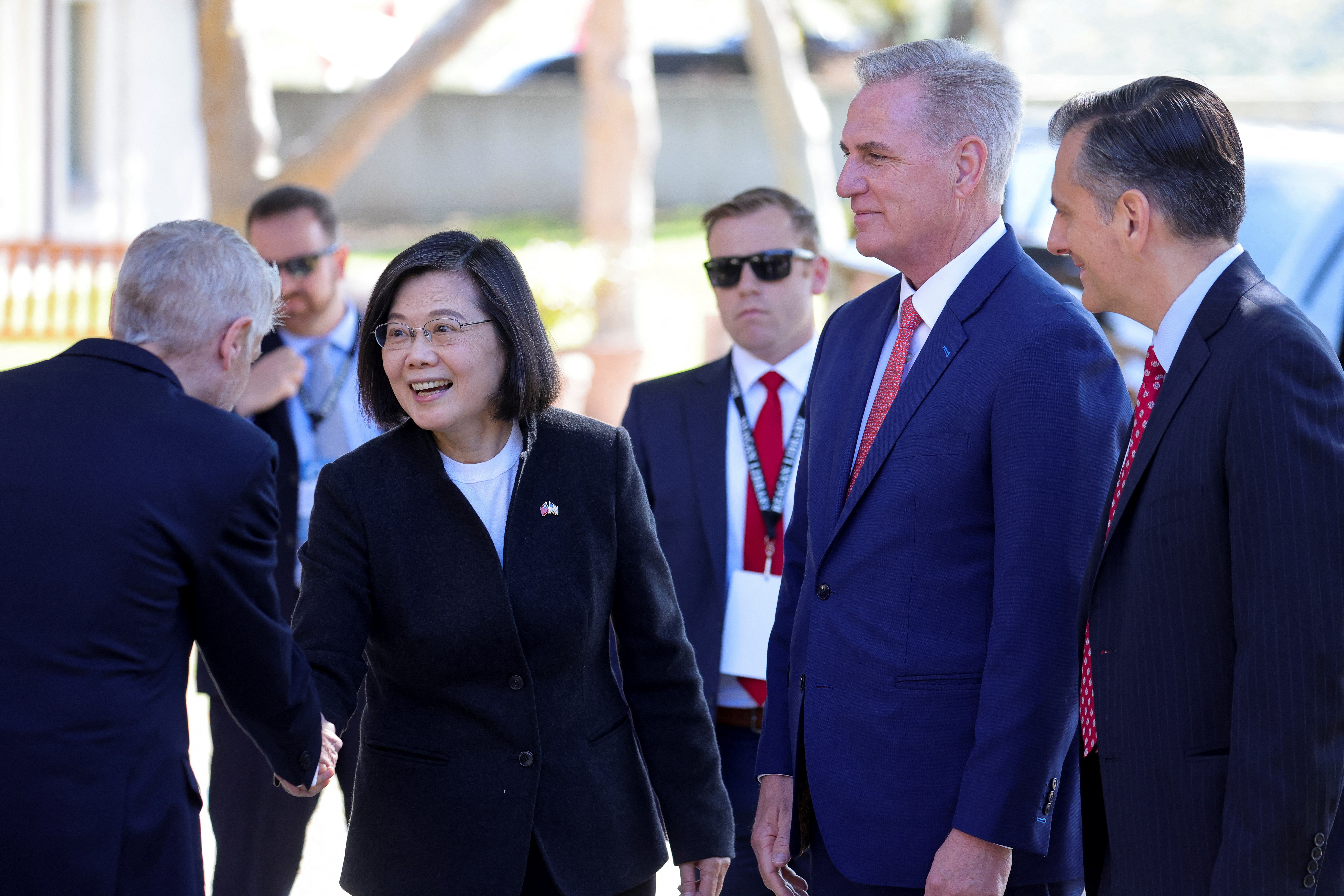 Tsai Ing-wen shakes hands with a politician, as Kevin McCarthy watches, standing next to her