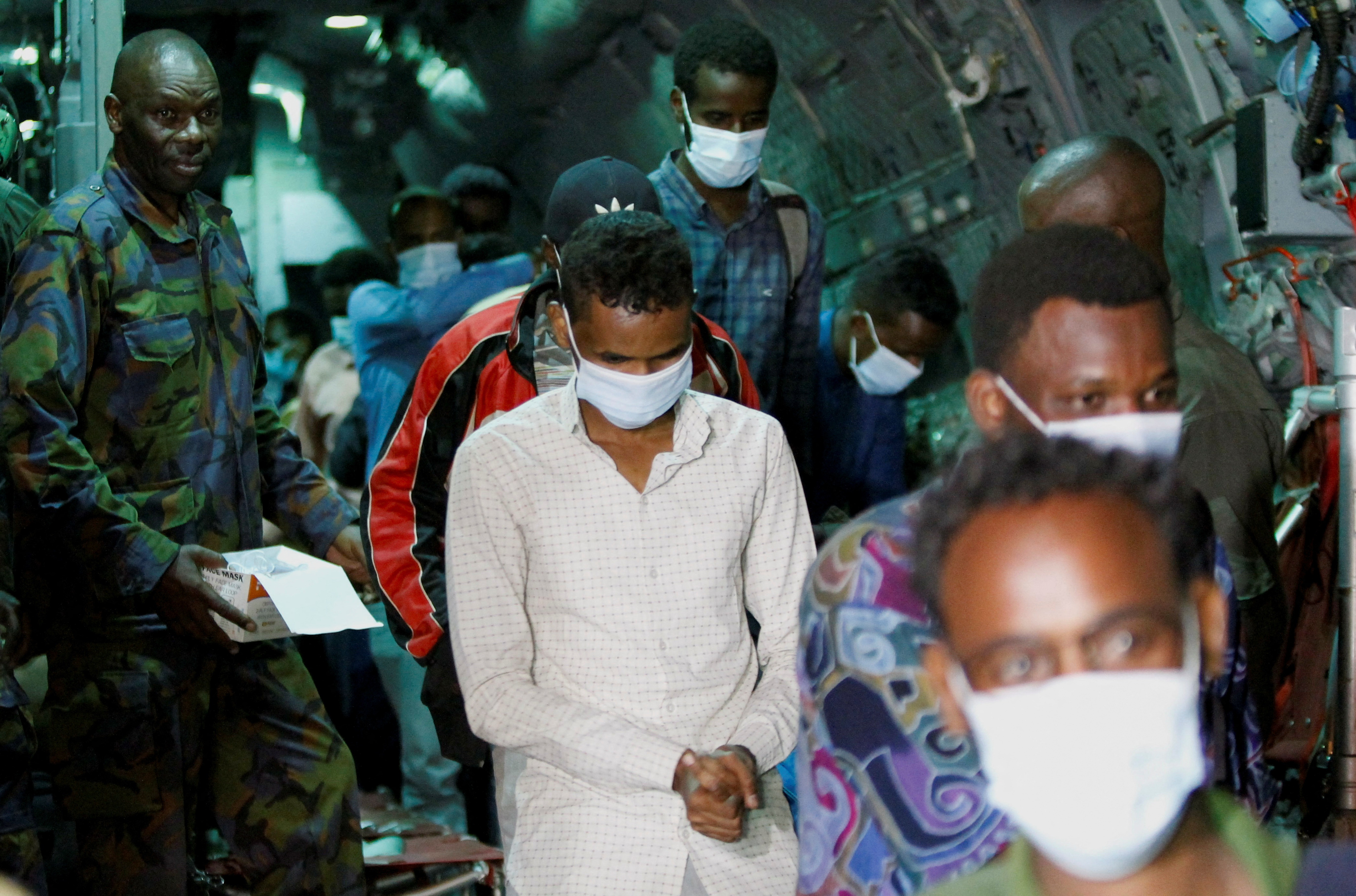 Evacuees from war-torn Sudan are processed by members of the Kenya Defence Forces (KDF) as they disembark from a military plane upon their arrival at the Jomo Kenyatta International Airport