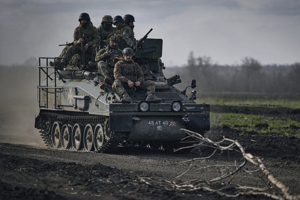 Ukrainian soldiers ride atop an APC on the frontline in Bakhmut, Donetsk region, Ukraine, Sunday, March 26, 2023. (AP Photo/Libkos)