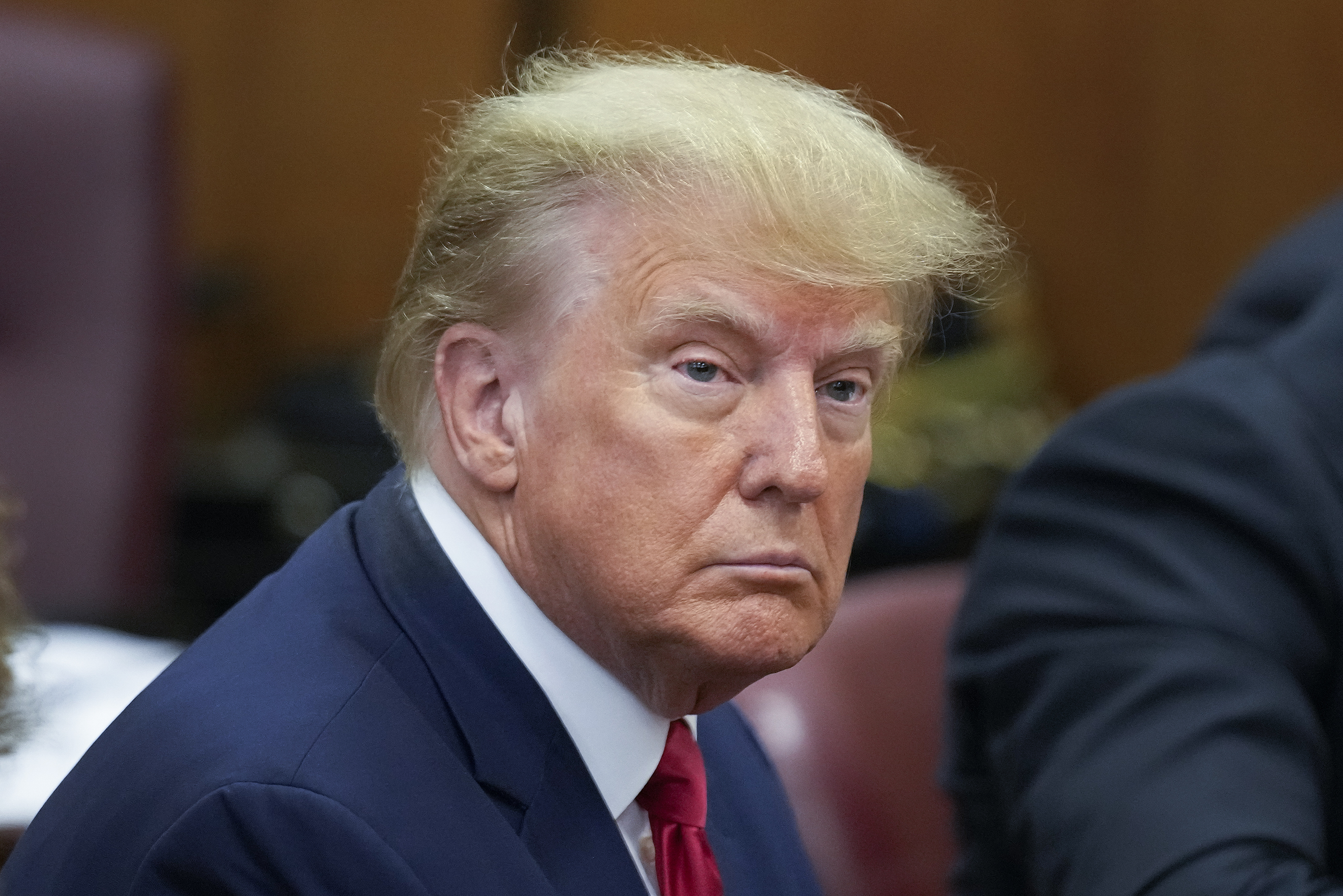 Former President Donald Trump sits at the defense table with his defense team in a Manhattan court