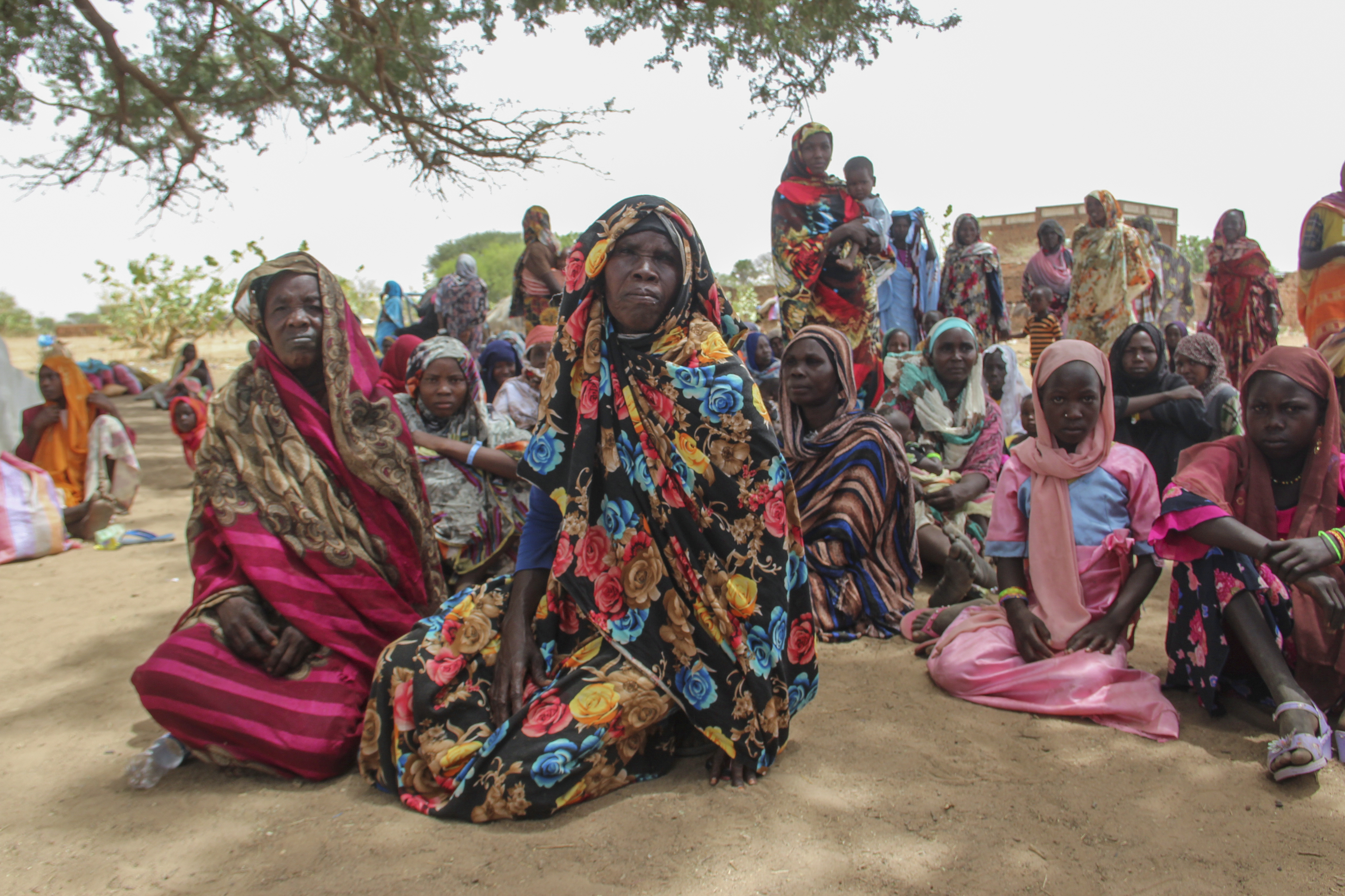 A group of refugees rests under the shade of a tree to protect themselves from the sun and heat after crossing into the village of Koufroun, near the Chad-Sudan border, in Chad