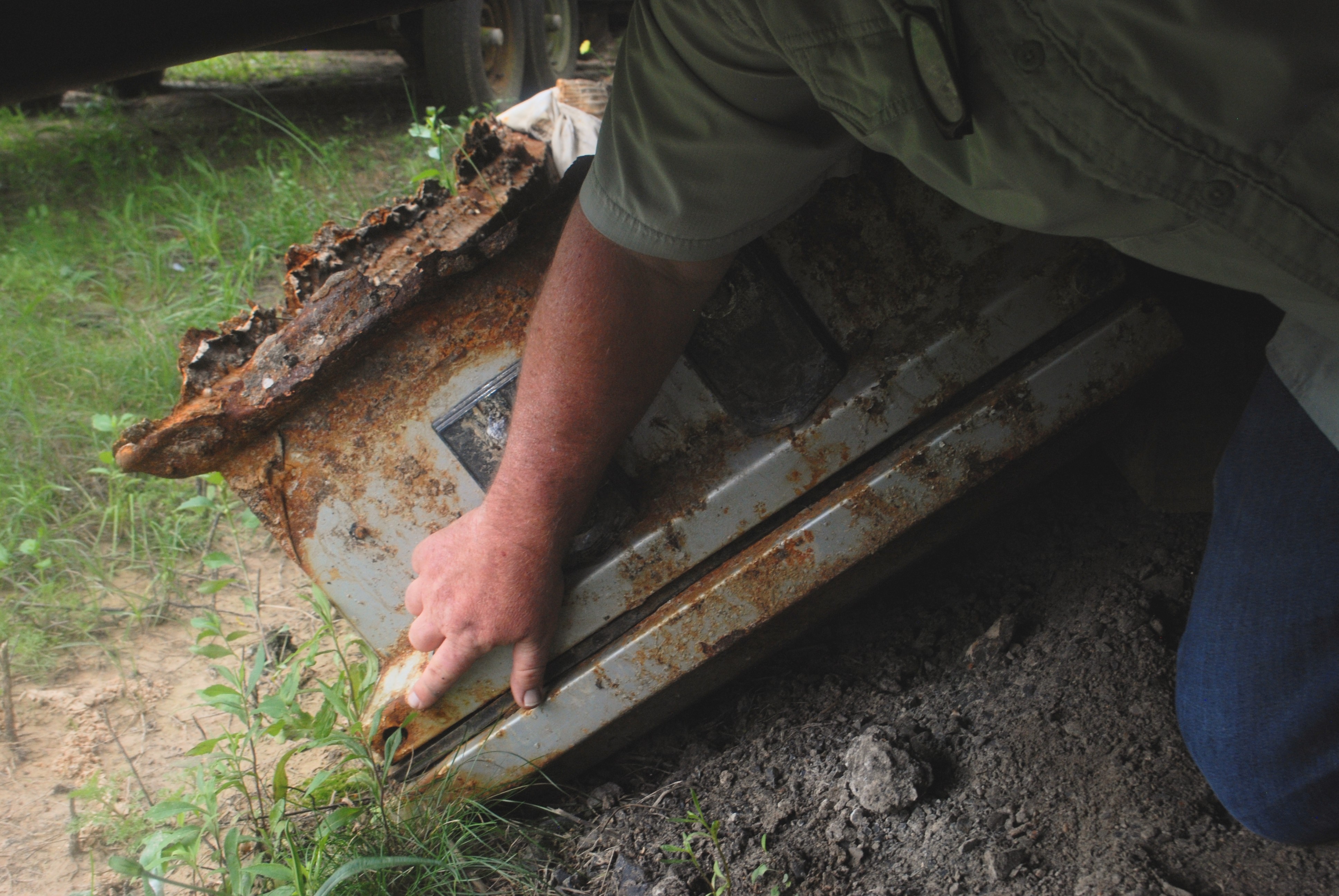 Hebert points to the corner of a casket he recovered after it was displaced by a hurricane. While the remains are missing, the corner held a small glass vial containing identifying information for the deceased