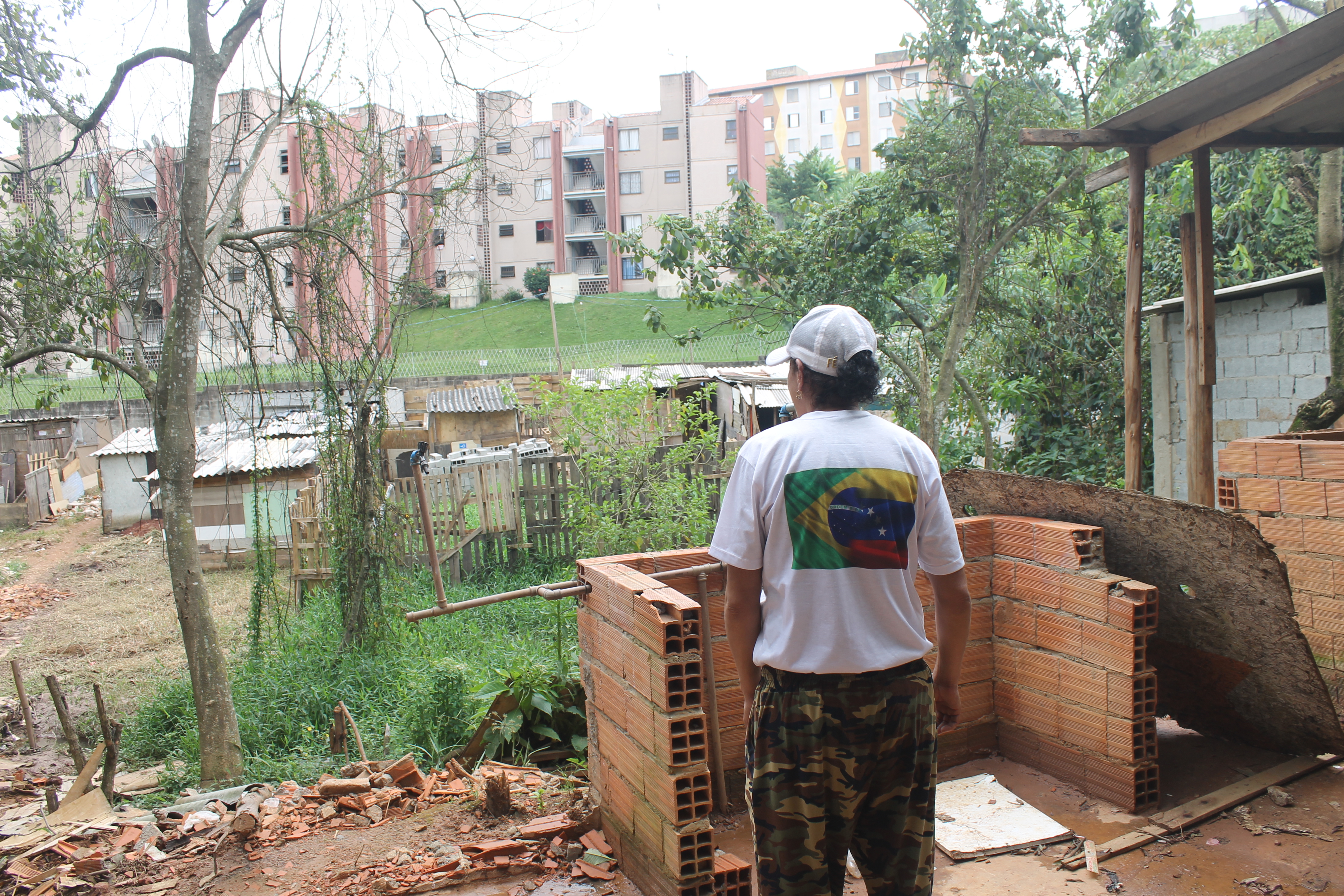 Community leader Debora Maria dos Santos stands in front of a destroyed kitchen in ‘Veneza City’