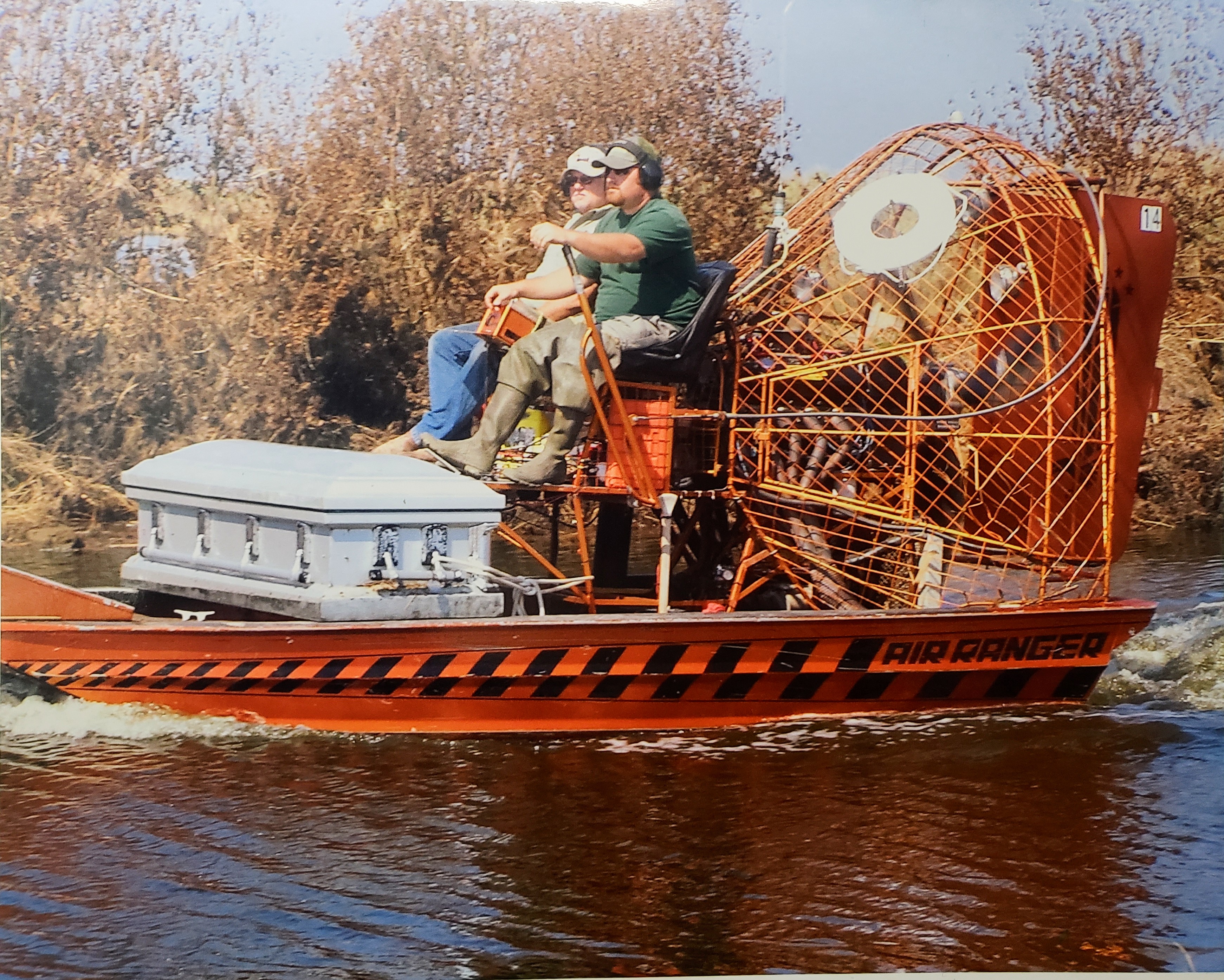 A 2005 photo of Patrick Hebert and his former colleague Joe driving an airboat in Cameron Parish, Louisiana, recovering caskets displaced by Hurricane Rita
