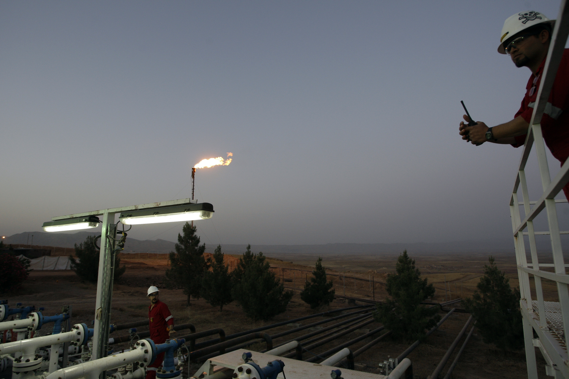Iraqi workers are seen at an oil refinery near the village of Taq Taq, in the autonomous Iraqi region of Kurdistan, on May 31, 2009. Iraq's self-ruled Kurdish region will begin exporting crude oil for the first time on June 1, piping up to 90,000 bpd to its neighbours, officials said. Initial exports will be around 40,000 barrels per day from the Taq Taq field in the province of Arbil and another 50,000 bpd from the Tawke field in Dohuk, company officials told AFP. AFP PHOTO/ALI AL-SAADI (Photo by ALI AL-SAADI / AFP)