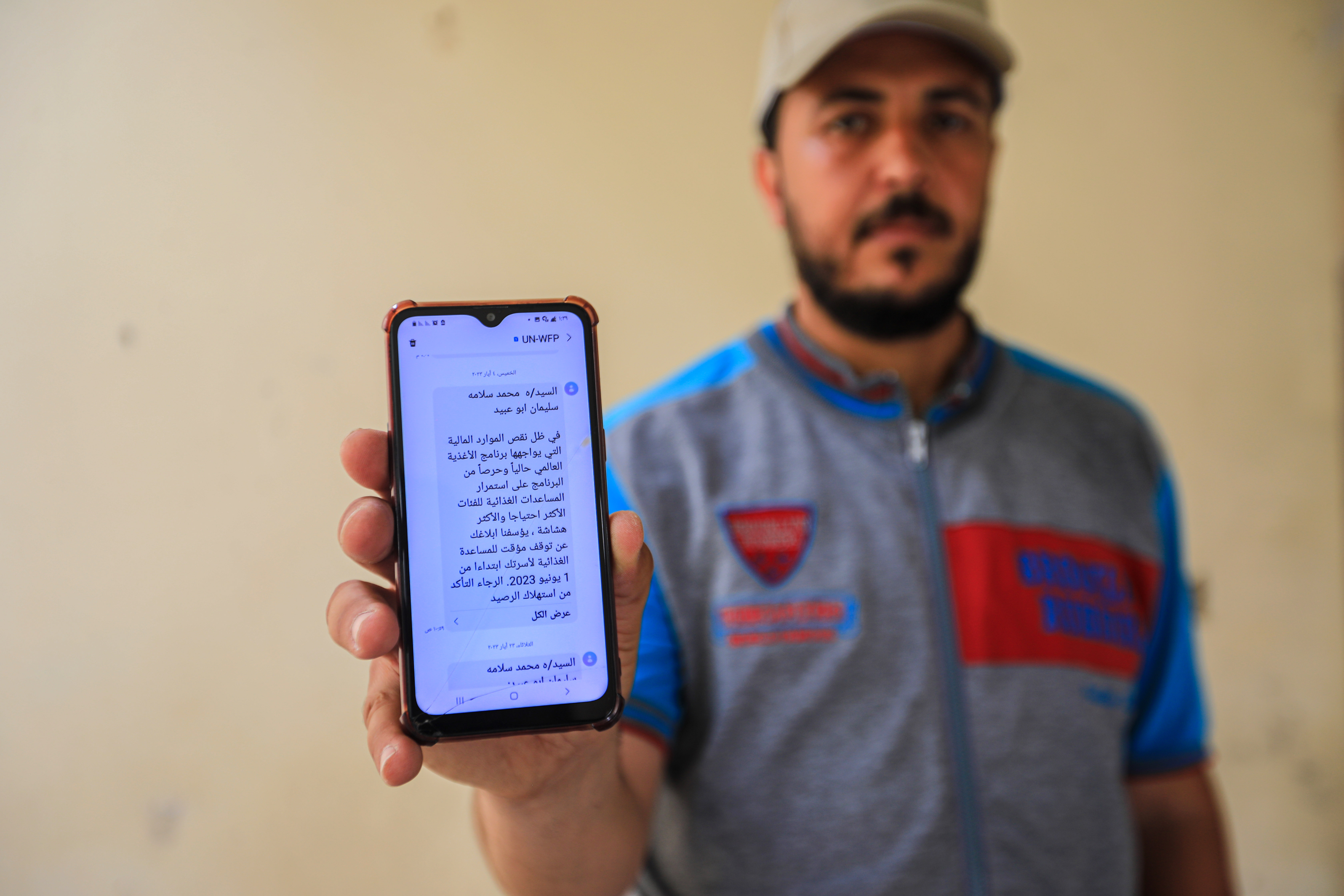 Aisha’s husband, Suliman, shows the WFP message of aid suspension