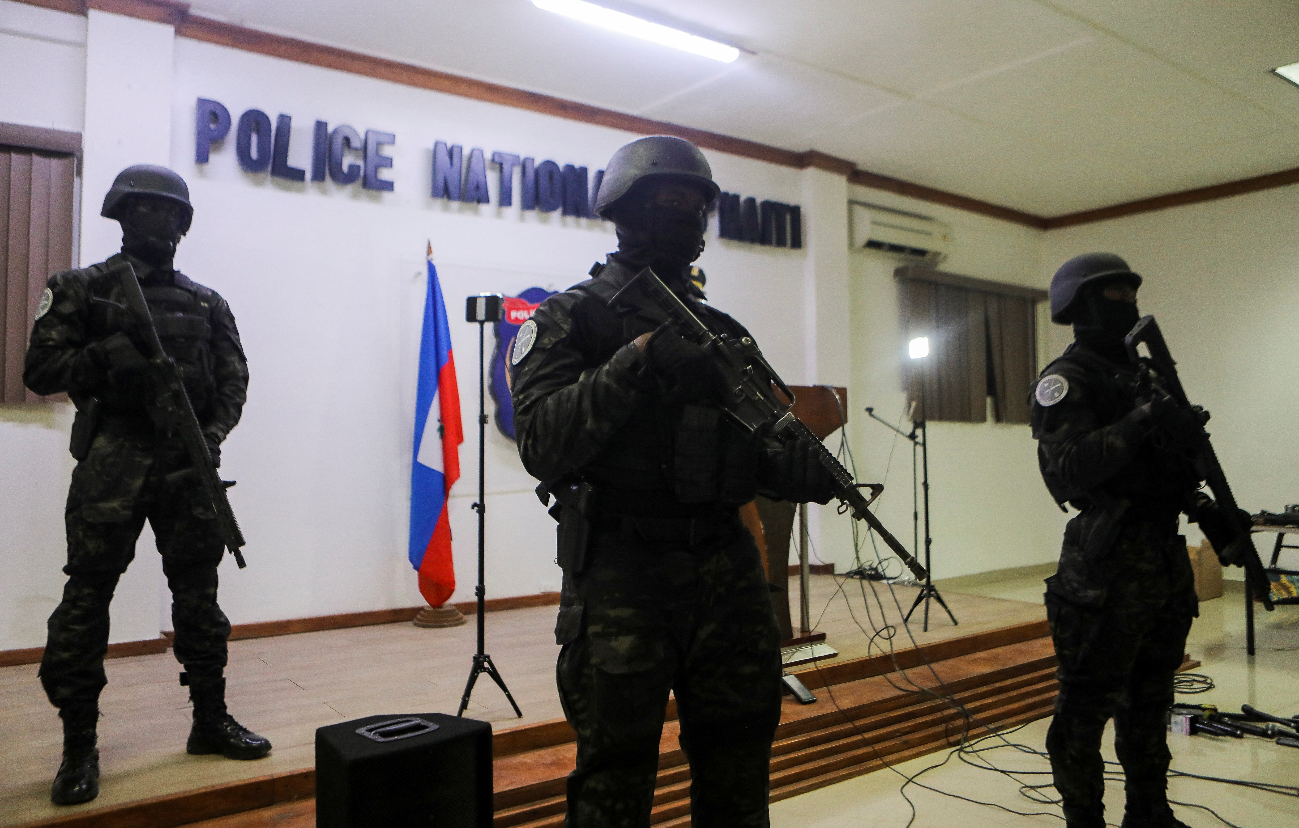Haitian National Police members stand guard during a news conference to present weapons confiscated during an anti-gang operation in Port-au-Prince