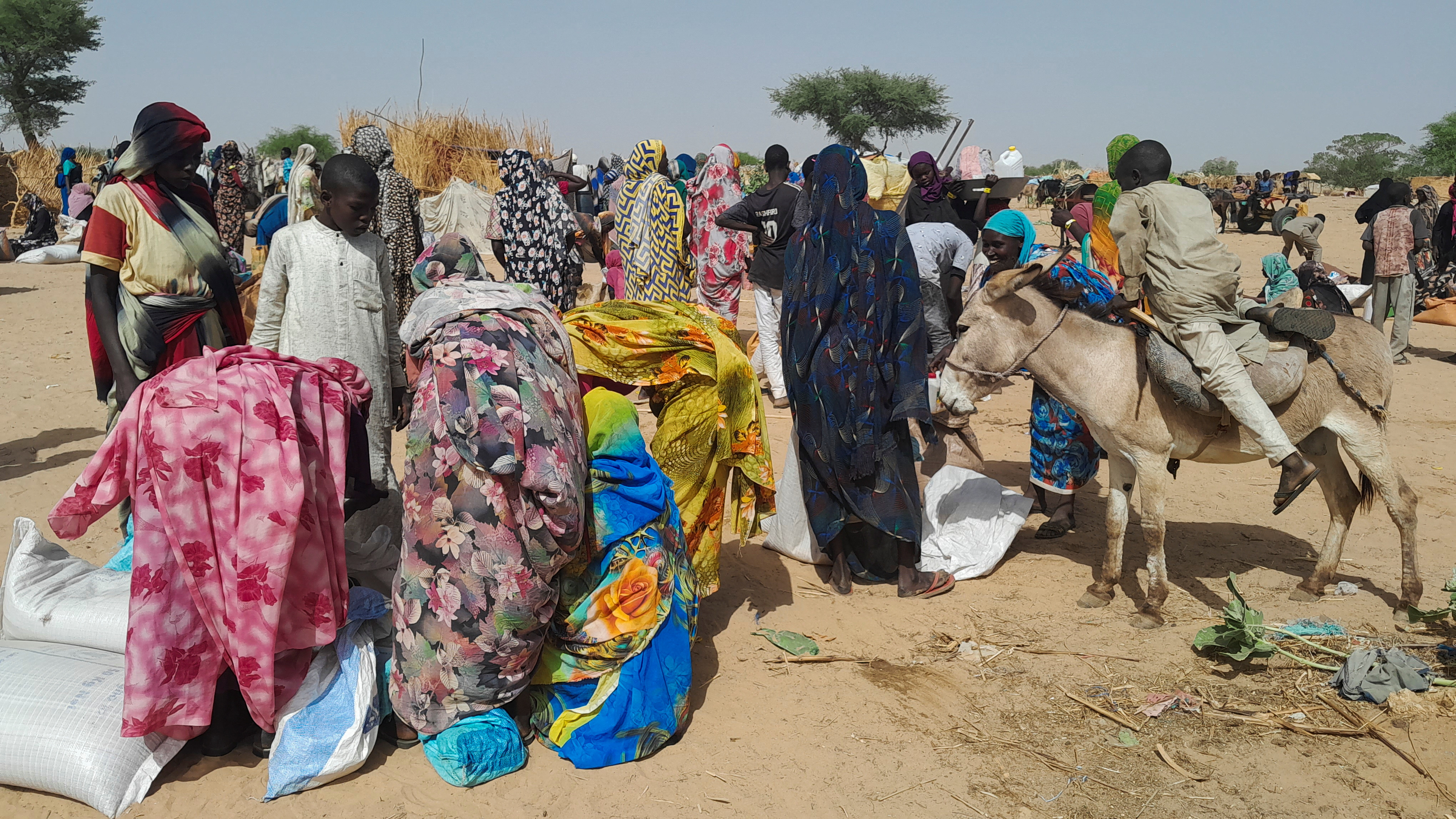 Sudanese refugees who fled the violence in their country, gather for food given by the World Food Programme (WFP) near the border between Sudan and Chad, in Koufroun, Chad April 28, 2023.