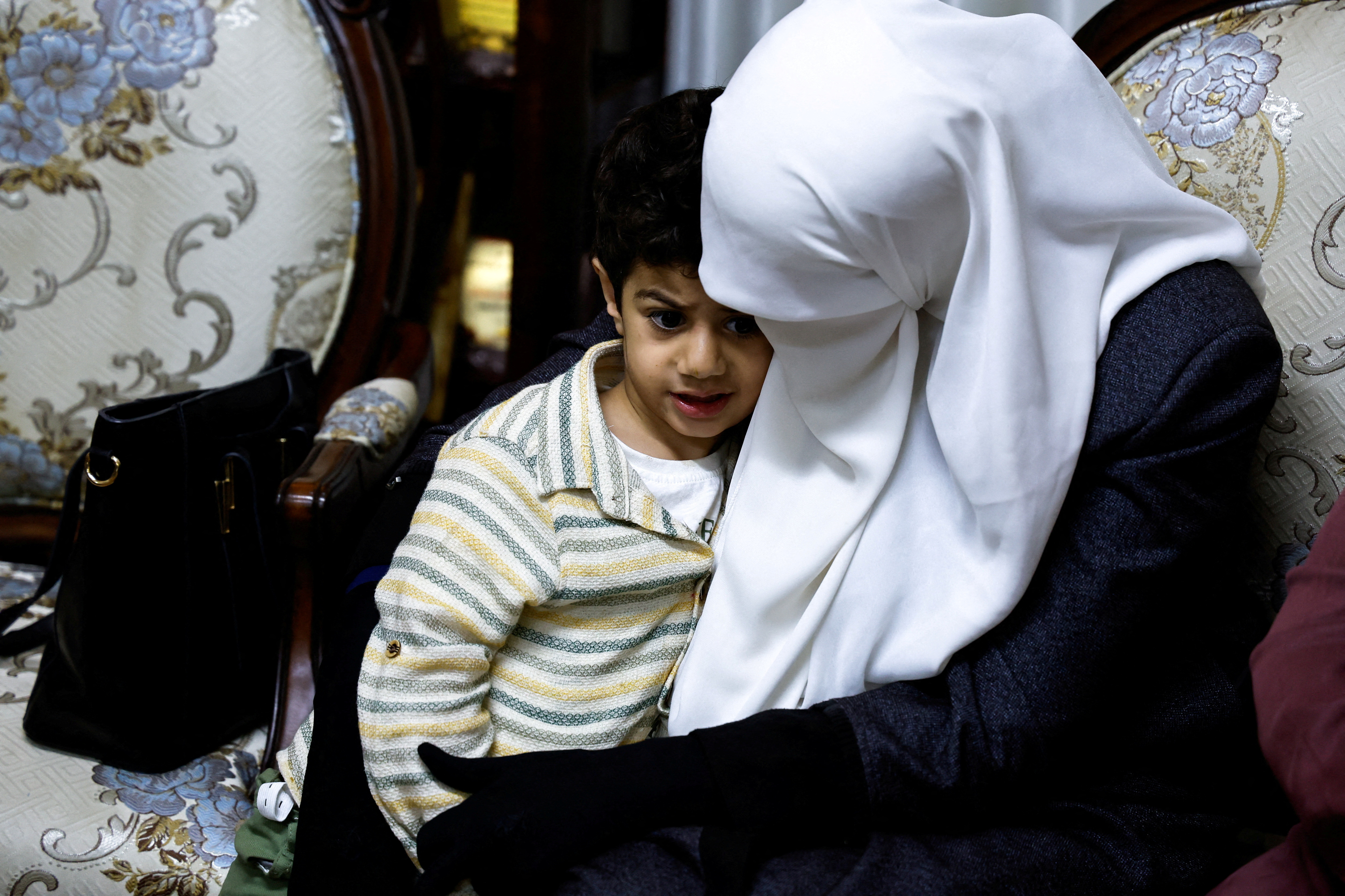 Randa Musa, wife of Palestinian prisoner Khader Adnan, who died in an Israeli jail during a hunger strike, sits with their son Ali, as Palestinians gather at their house, near Jenin in the Israeli-occupied West Bank May 2,2023. REUTERS/Raneen Sawafta