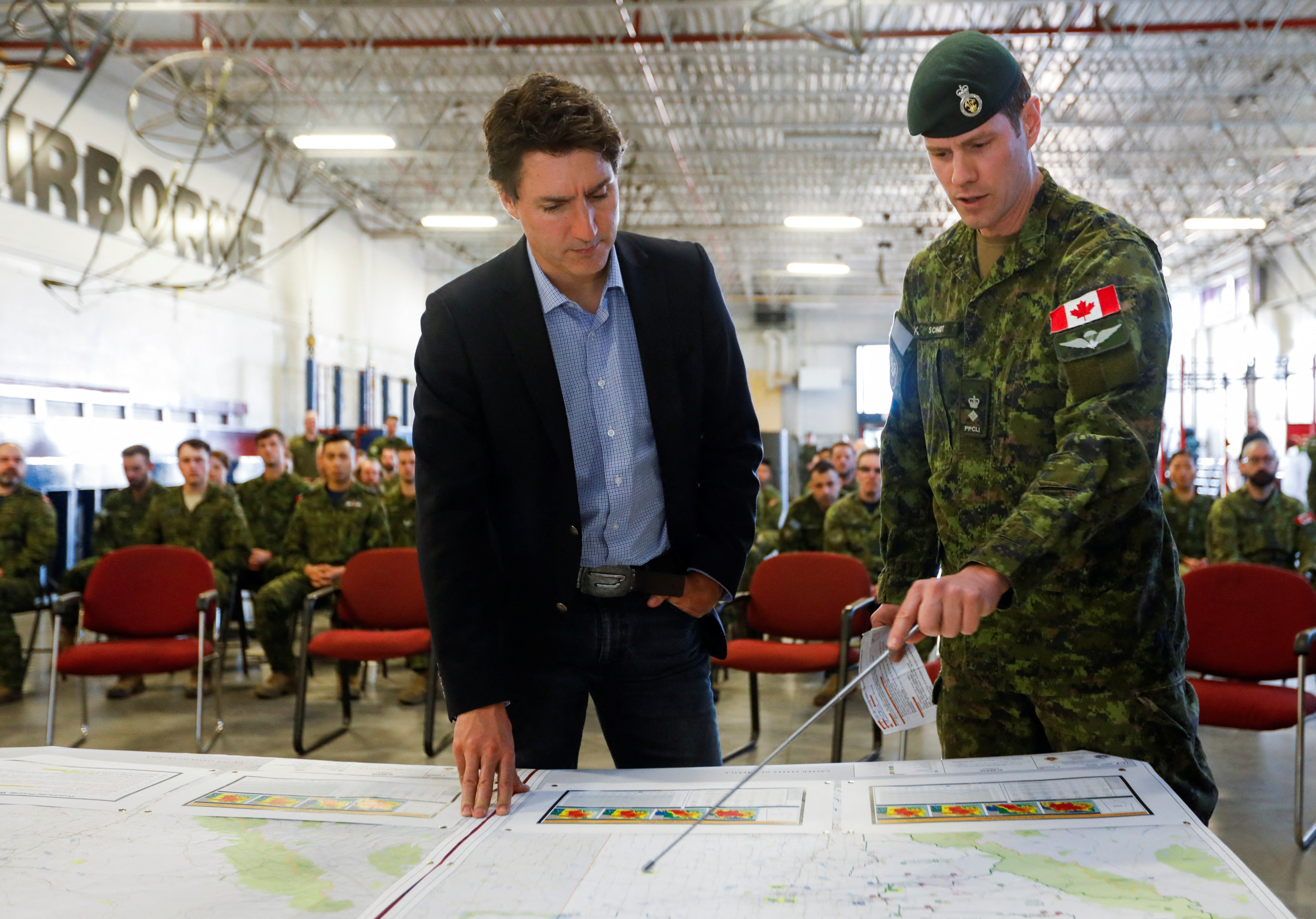 Canadian Prime Minister Justin Trudeau is briefed about wildfires in Alberta by a member of the Canadian Armed Forces in Edmonton.