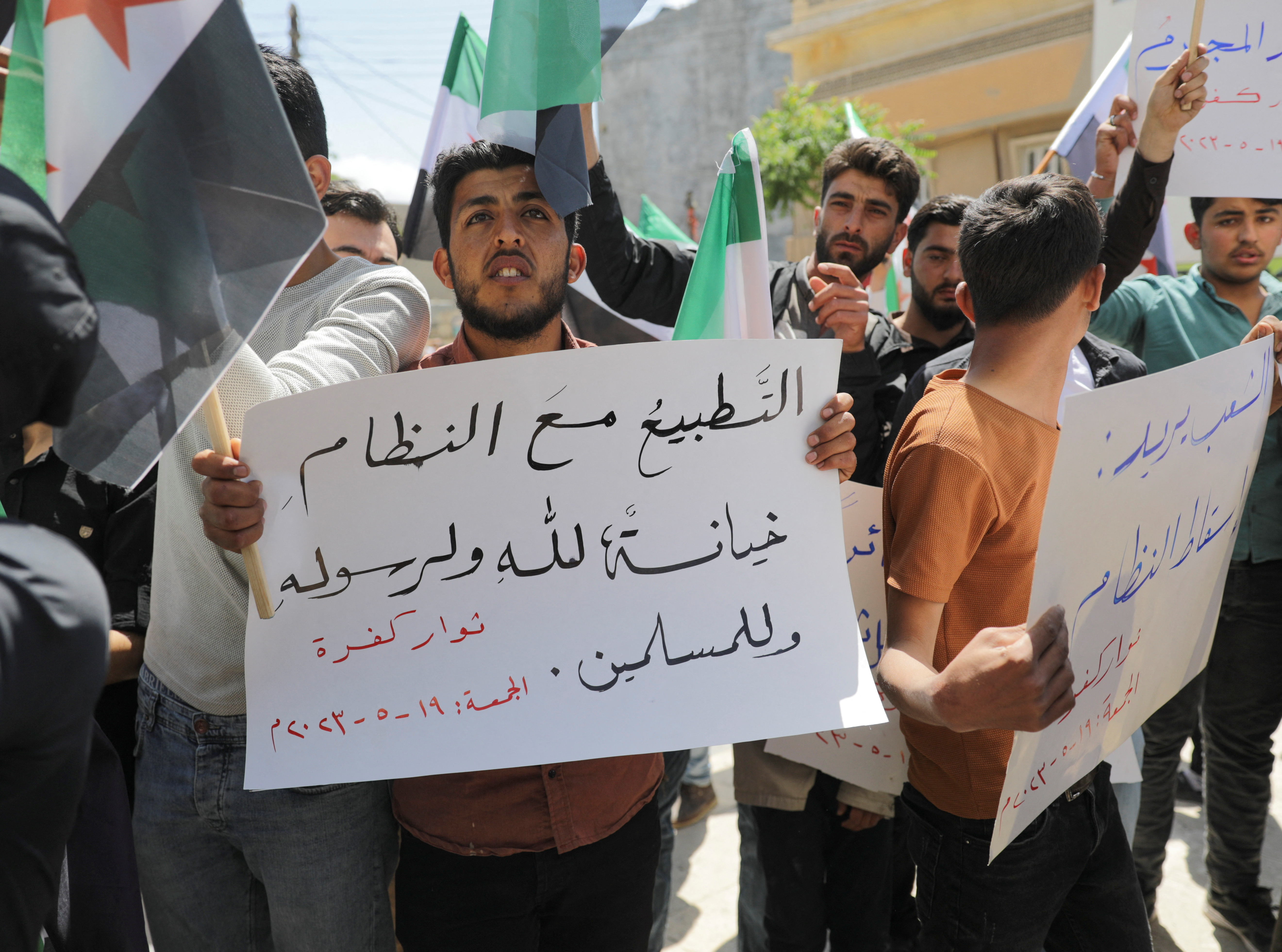 A demonstrator holds a sign reading ‘Normalising with the regime, is a betrayal of God, his prophet and Muslims’ during a protest against Arab normalisation with Syria’s President Bashar al-Assad and the Arab League’s reintegration of Syria, in the rebel-held city of Azaz