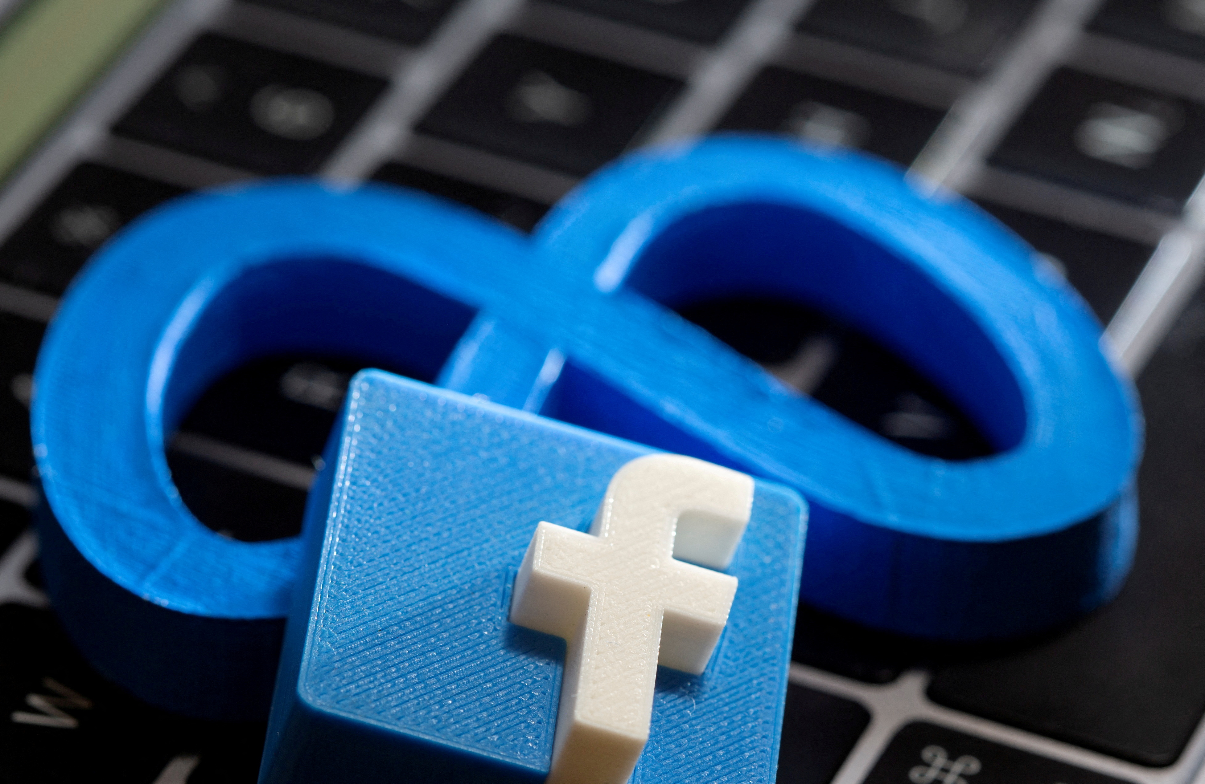 A 3D printed Facebook's new rebrand logo Meta and Facebook logo are placed on laptop keyboard in this illustration taken on November 2, 2021