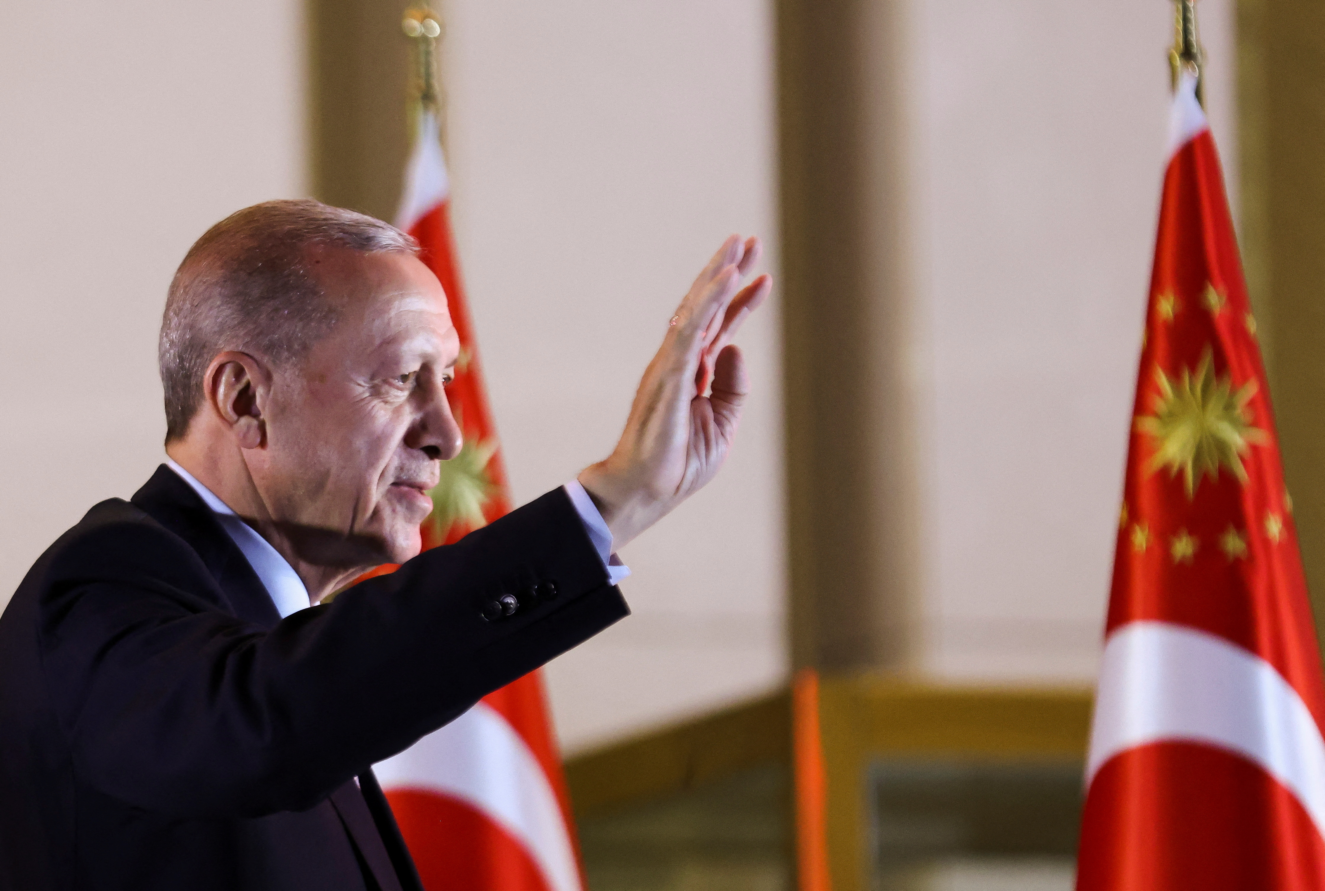 Turkish President Tayyip Erdogan waves as he addresses his supporters following his victory