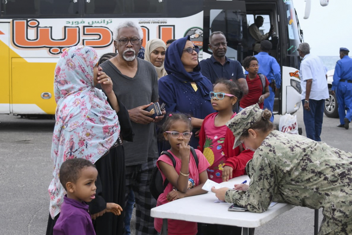 A picture taken on April 30, 2023, shows a member of the US military assisting US nationals fleeing war-torn Sudan in boarding an evacuation vessel in Port Sudan amid ongoing deadly clashes between Army forces and paramilitaries
