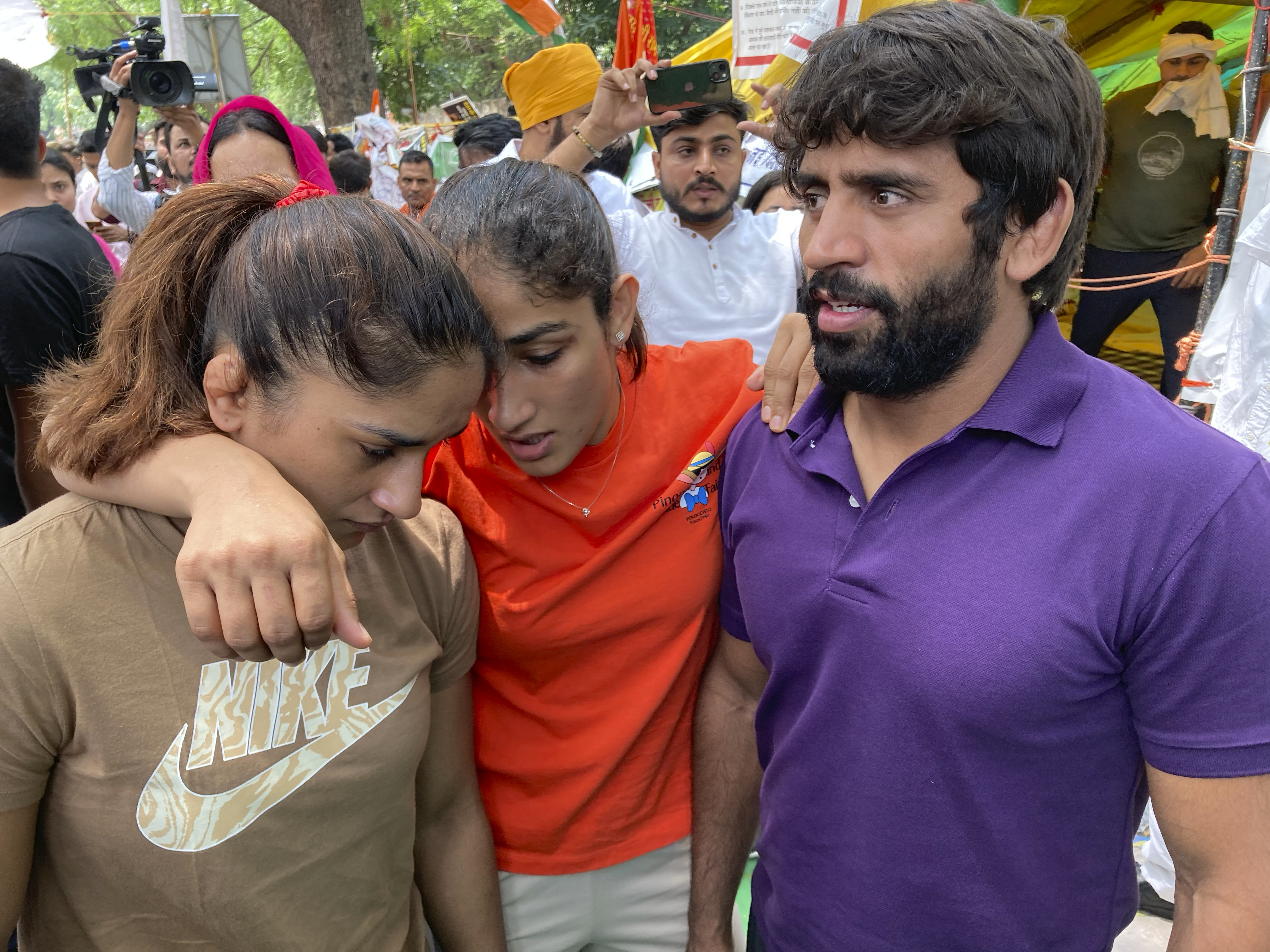 Indian wrestlers, from right, Bajrang Punia, Sangita Phogat and Vinesh Phogat embrace before their protest march towards the new parliament building in New Delhi