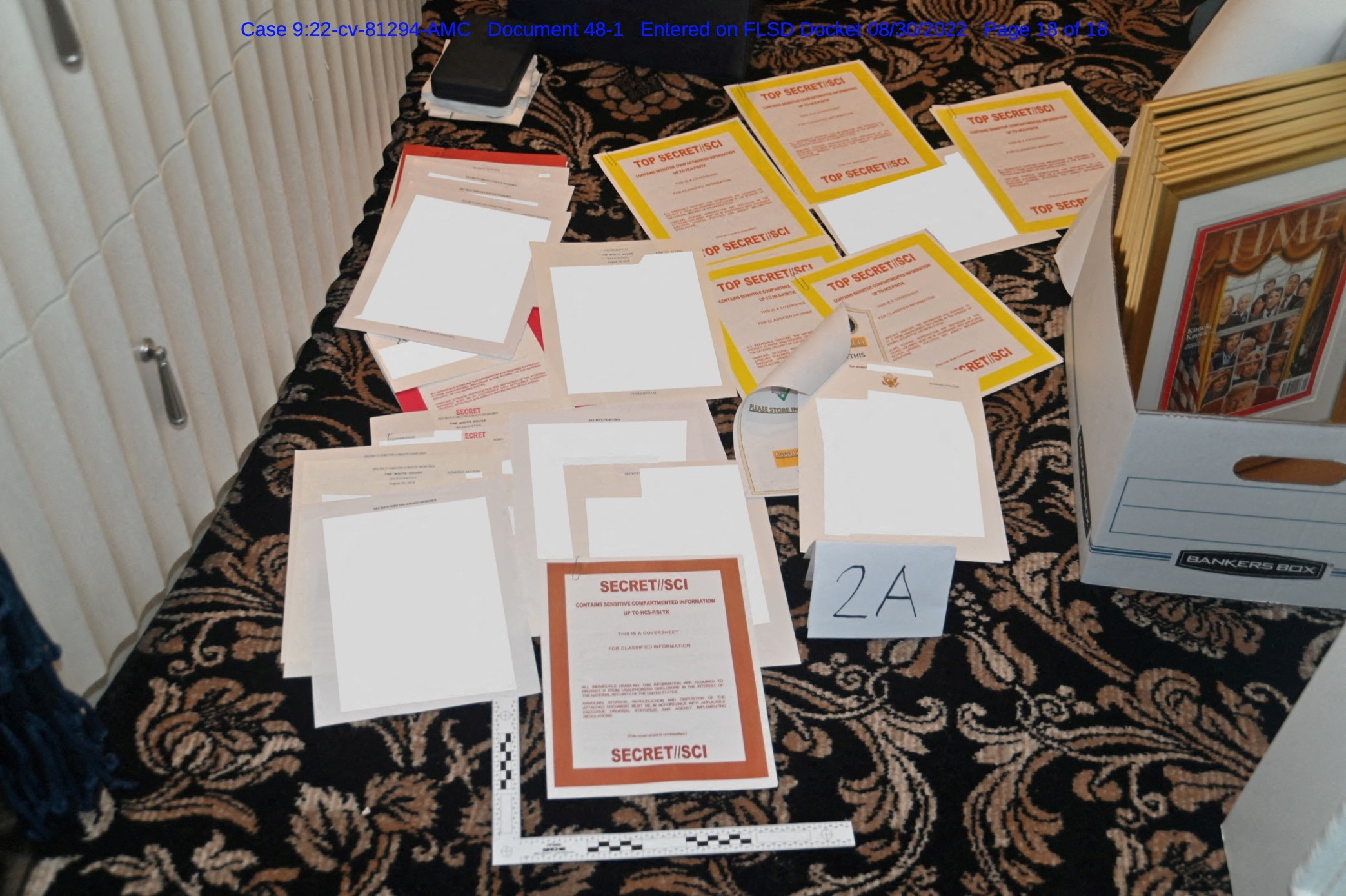 A redacted FBI photograph of documents and classified cover sheets recovered from a container stored in Trump’s Florida estate