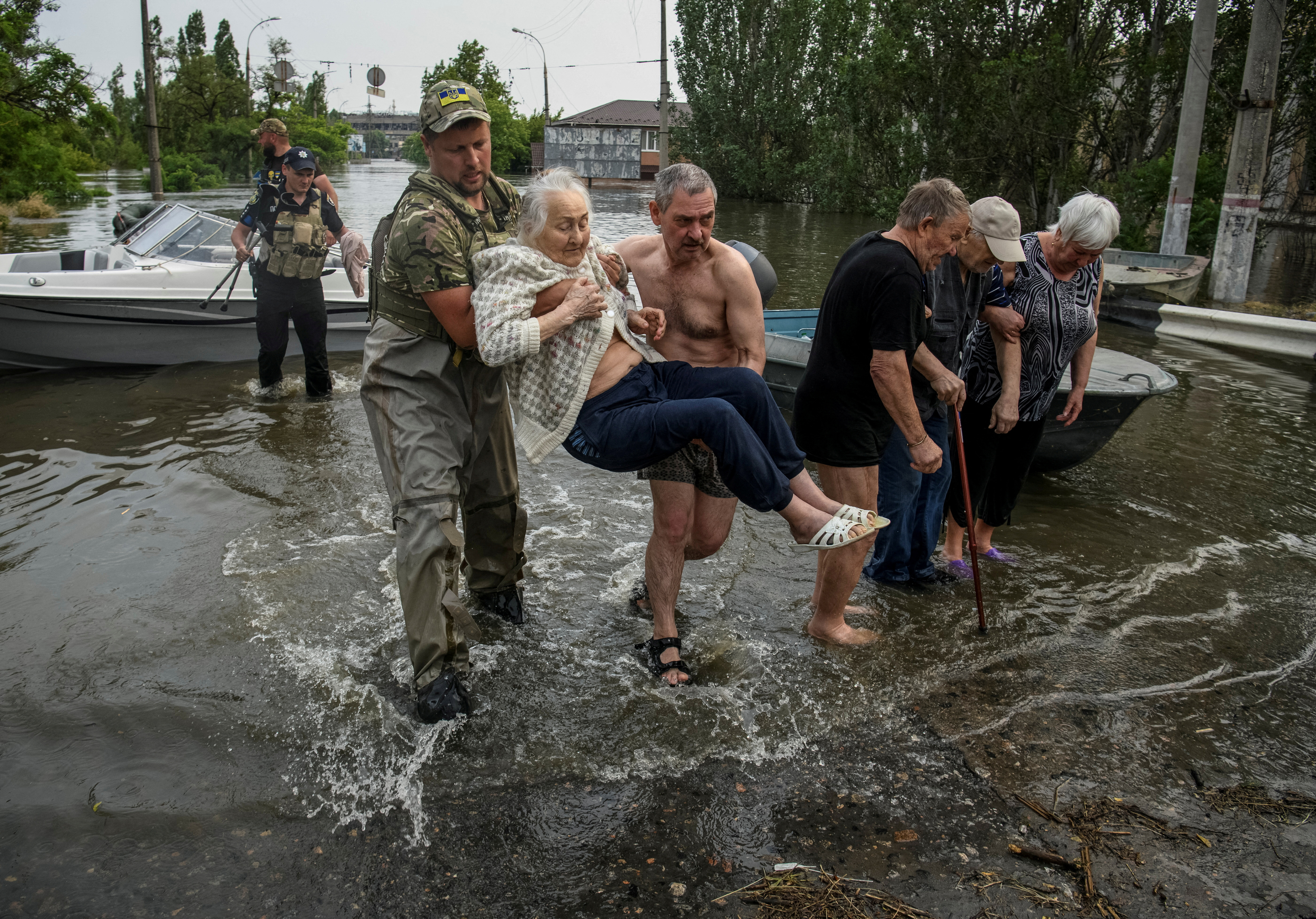 Rescuers evacuate local residents from a flooded area after the Nova Kakhovka dam breach, in Kherson, Ukraine, June 7, 2023