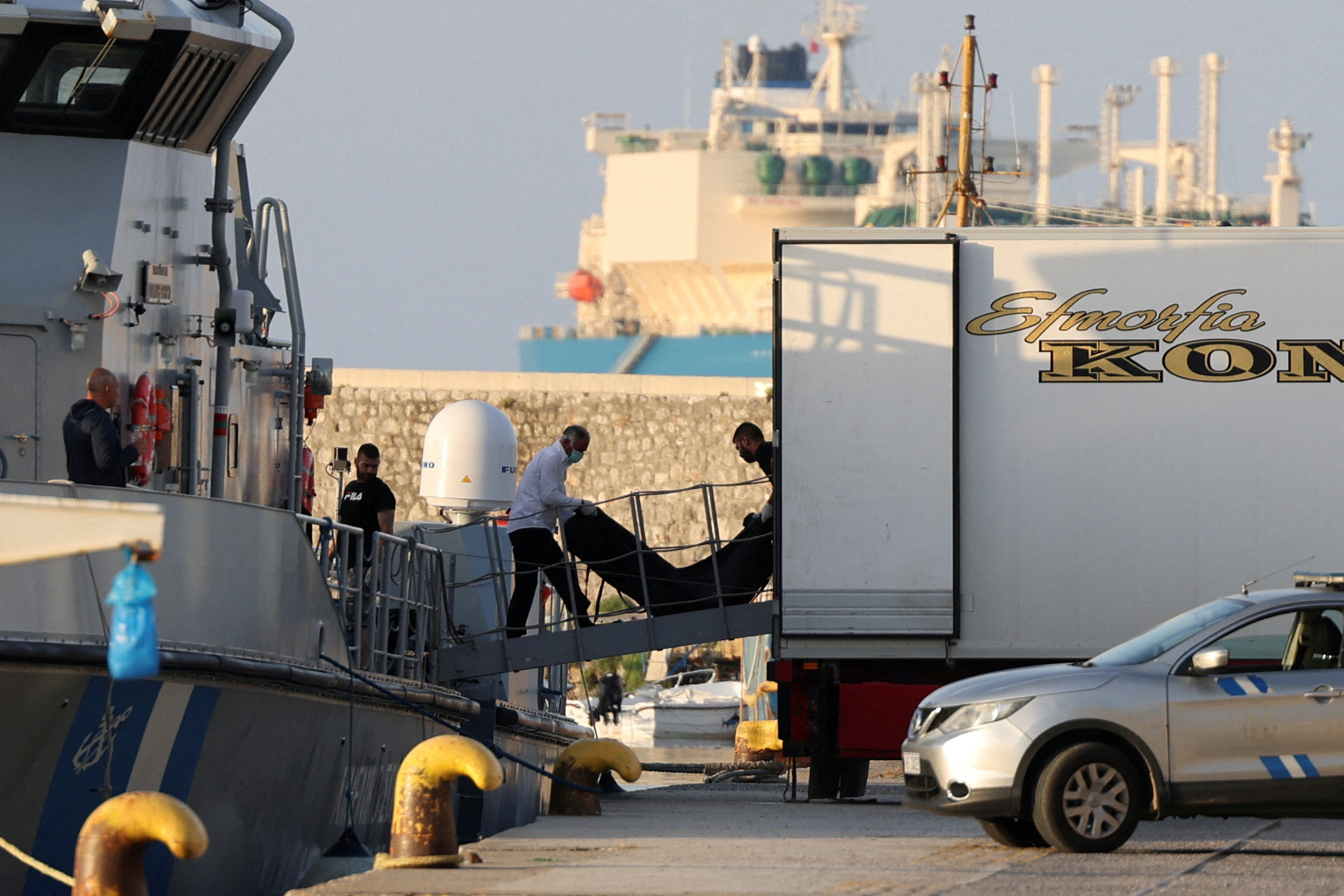 Men transfer body bags carrying migrants who died after their boat capsized in the open sea off Greece, onboard a Hellenic Coast Guard vessel at the port of Kalamata, Greece, June 15, 2023. REUTERS/Stelios Misinas TPX IMAGES OF THE DAY