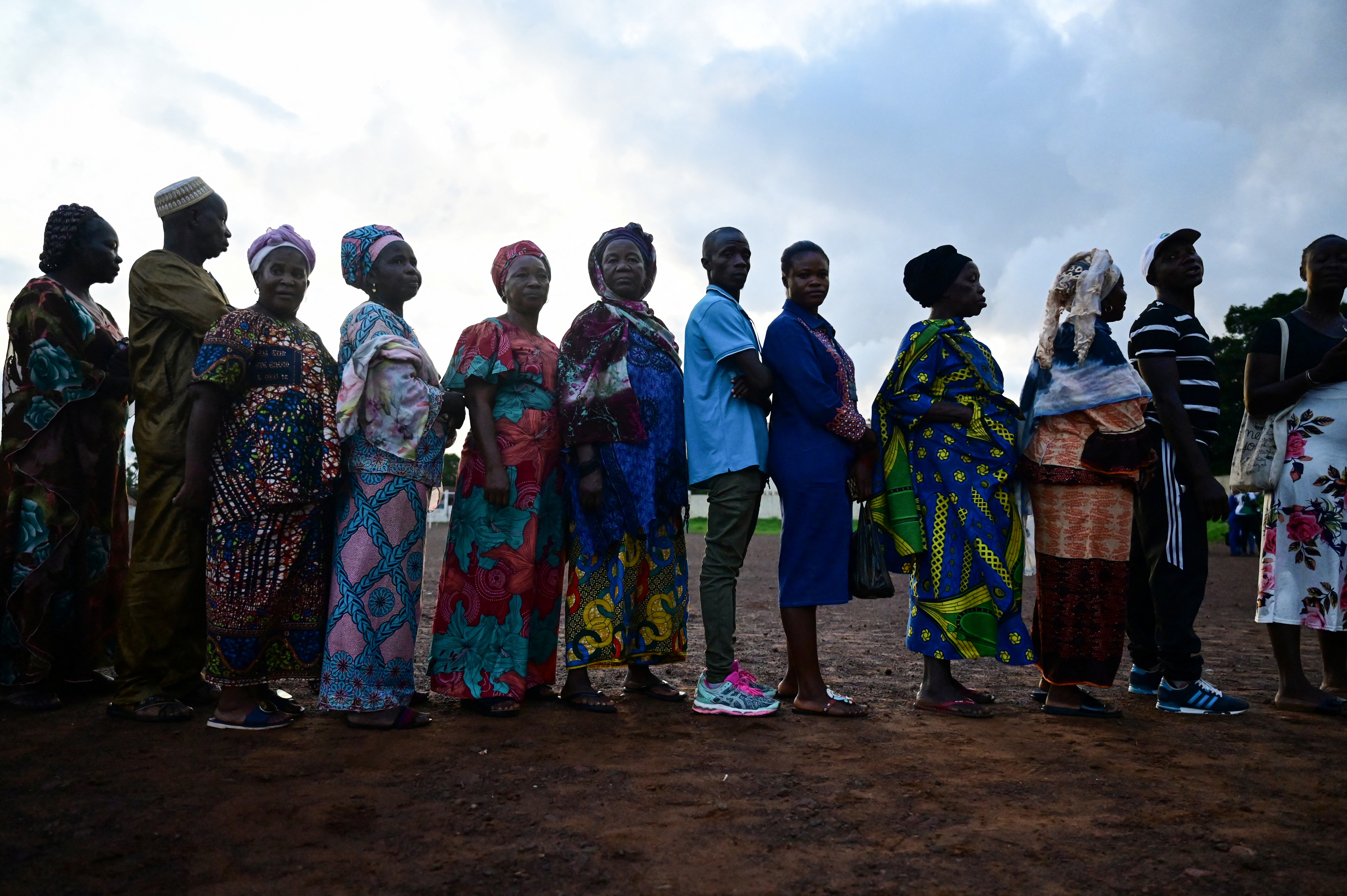 People wait to cast their votes for the national election at a polling station in Freetown