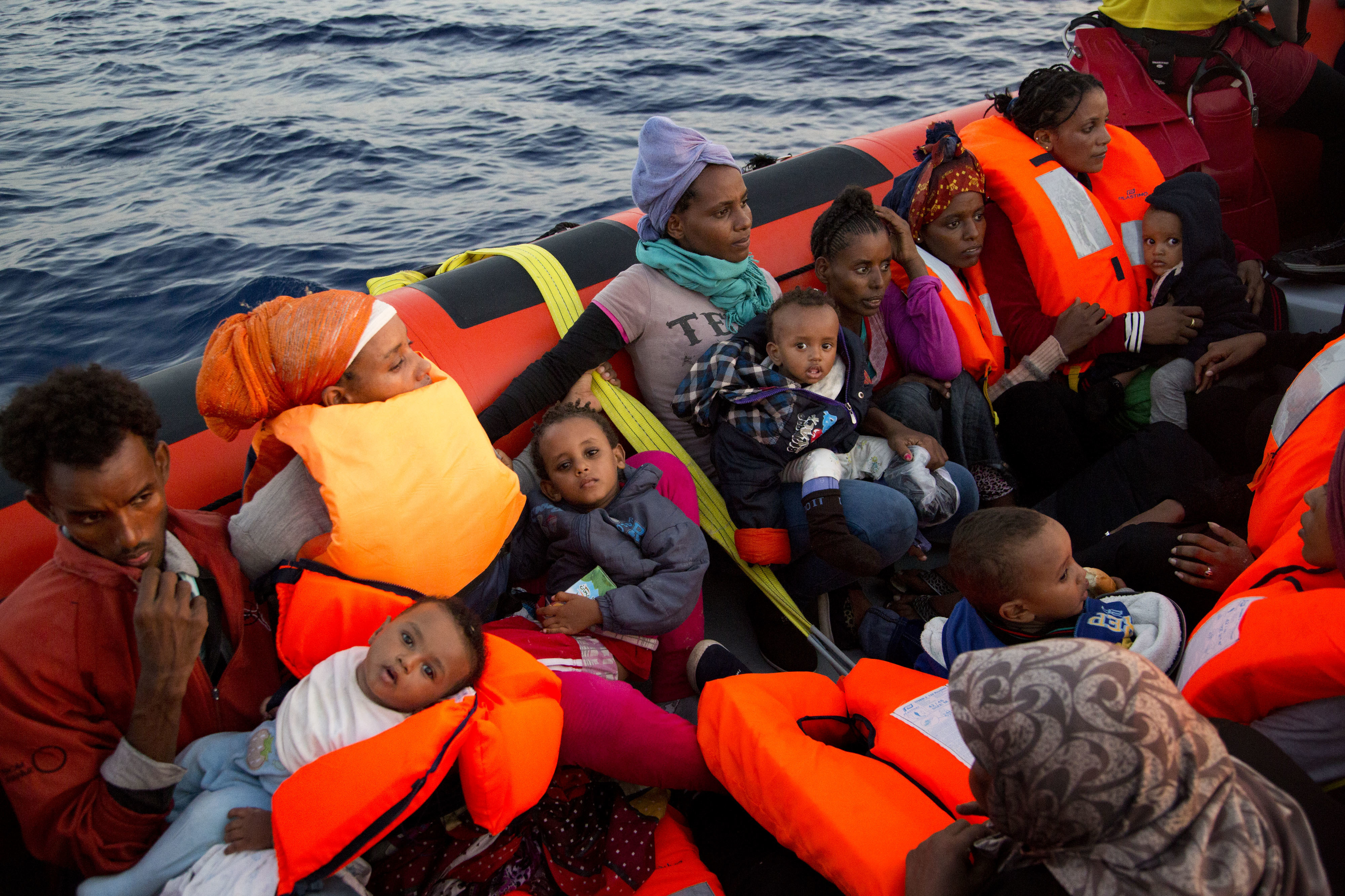 Migrants from Eritrea hold their children after been rescued from a crowded wooden boat