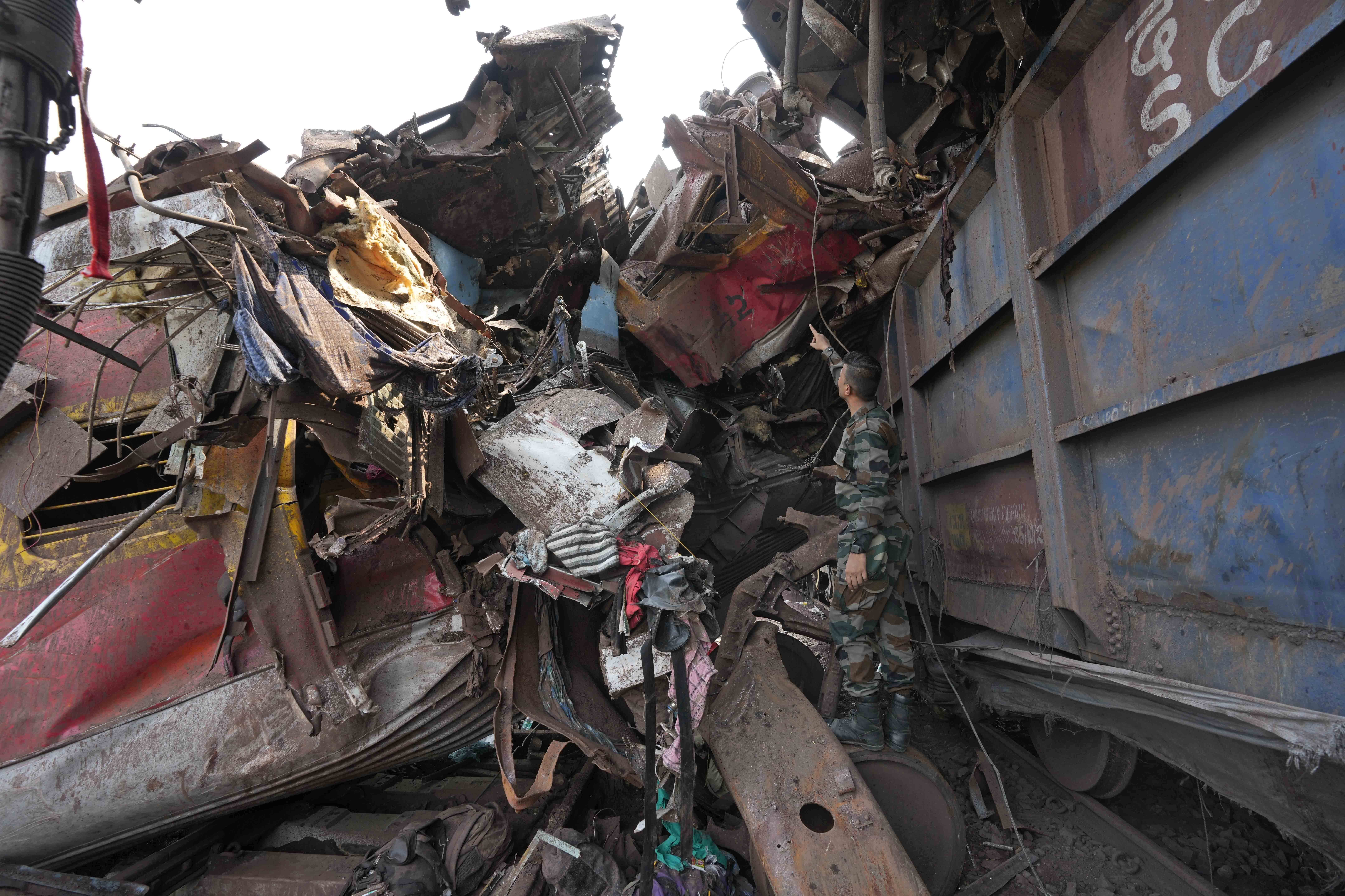 Rescuers work at the site of passenger trains in Odisha