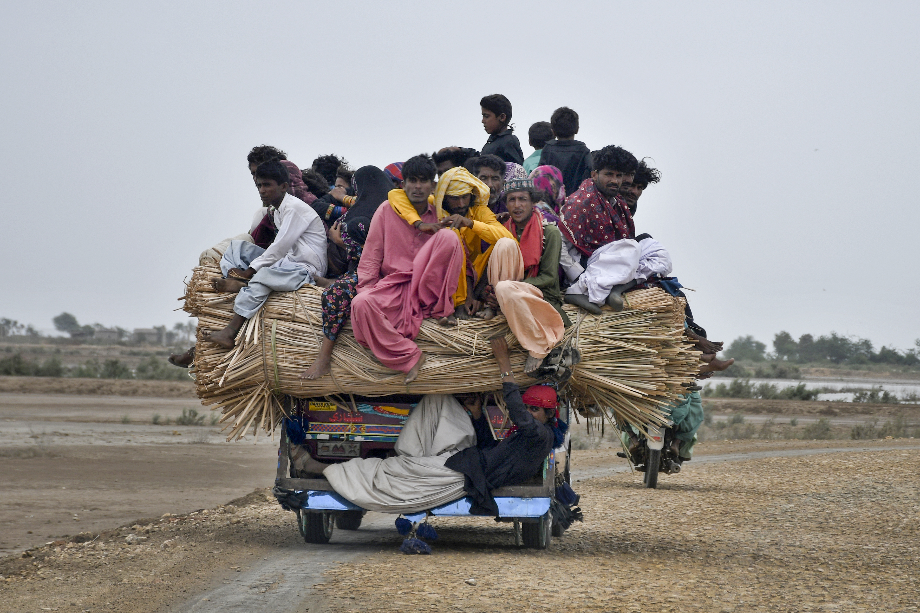 Local residents travel on a vehicle as they flee from a coastal village due to Cyclone Biparjoy approaching, in Golarchi near Badin, Pakistan's southern district in the Sindh province