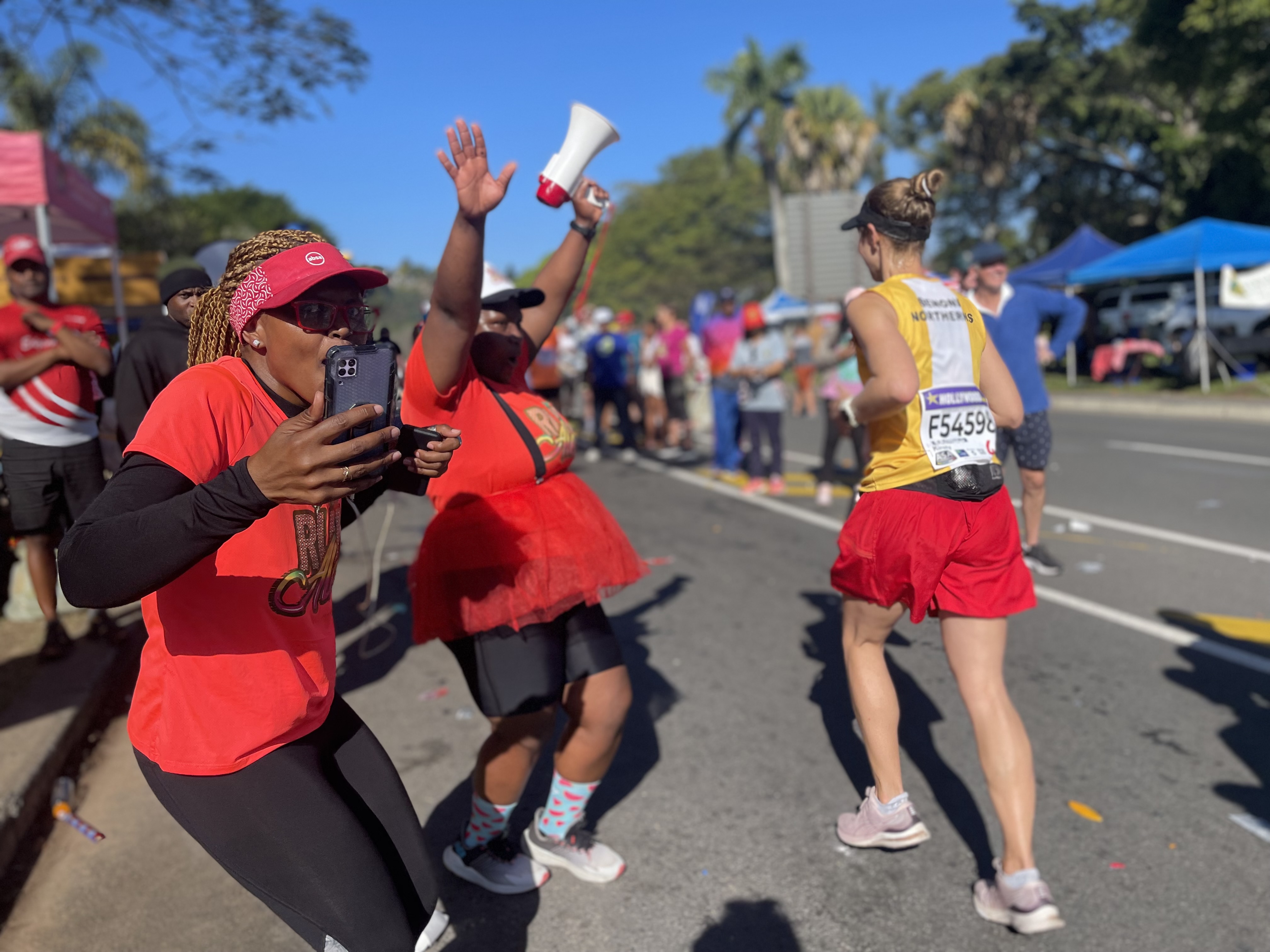 Members of Ashleigh Adams' running club, Run Alex, cheering for Comrades participants near the race's 70 kilometer mark in Pinetown, a suburb of Durban, South Africa.