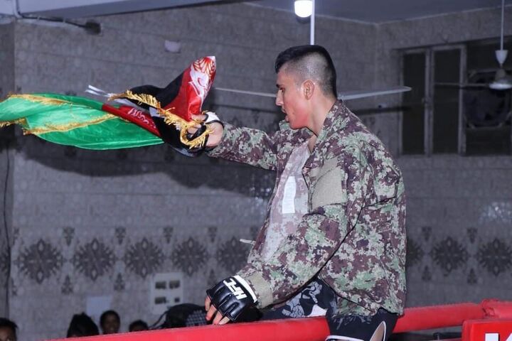 Hashime with the Afghan flag during an international bout [Sayed Waris Hashime]