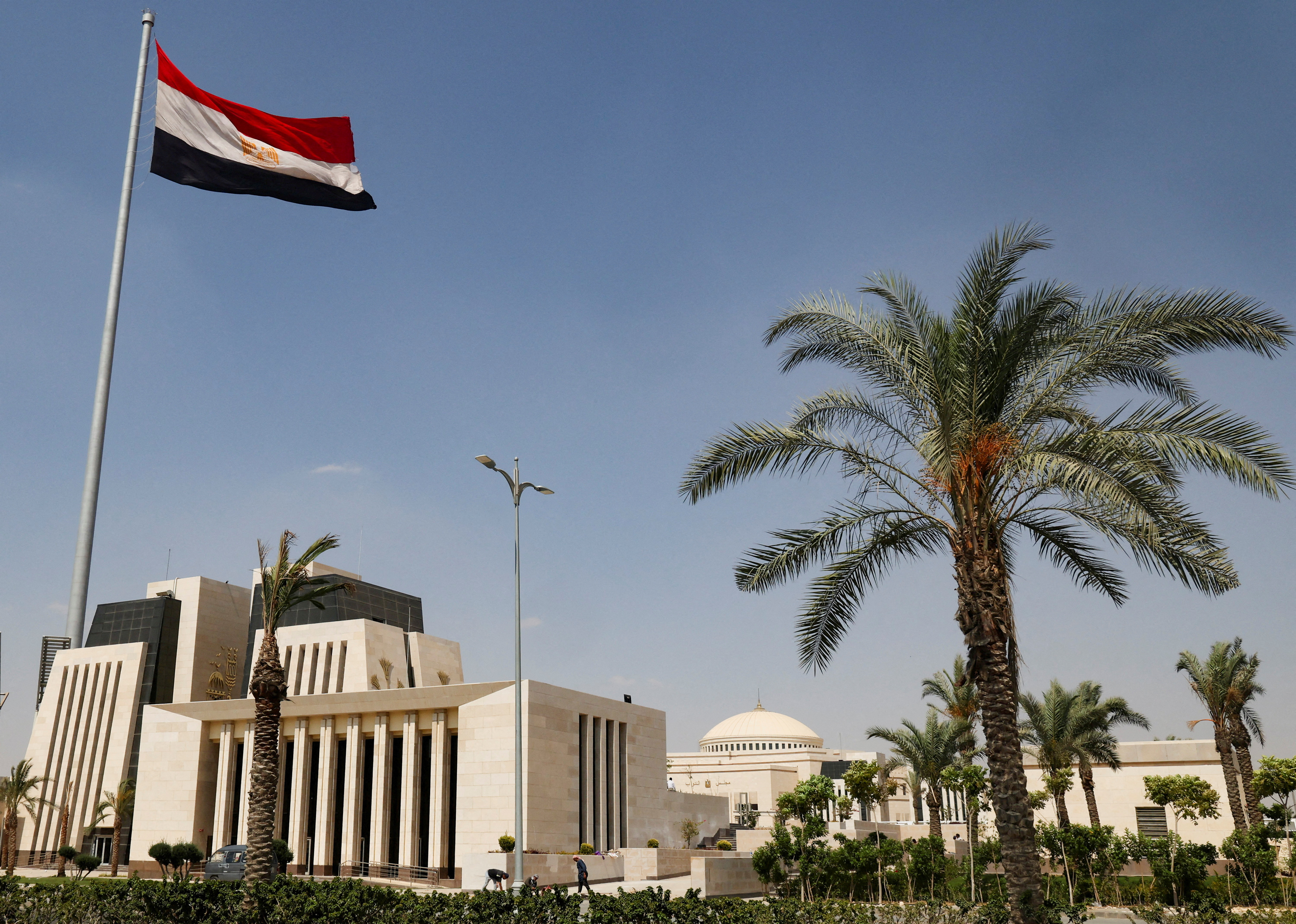 Egyptian workers are seen in front of the new headquarters of Egypt's parliament in the New Administrative Capital (NAC) east of Cairo