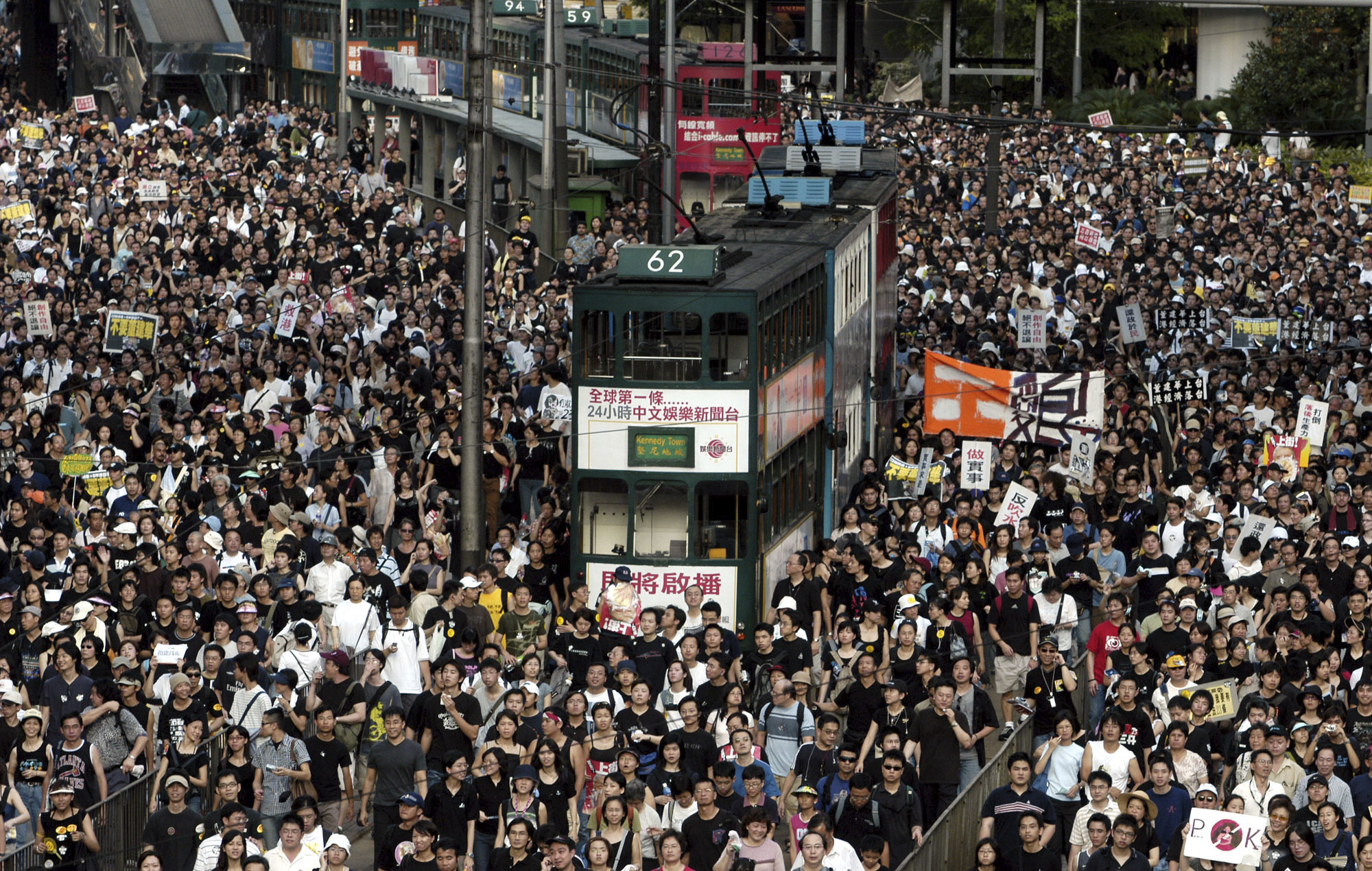 Tens of thousands of people pack a street while marching to Hong Kong government headquarters to protest against its plans to enact an anti-subversion bill, on July 1, 2003