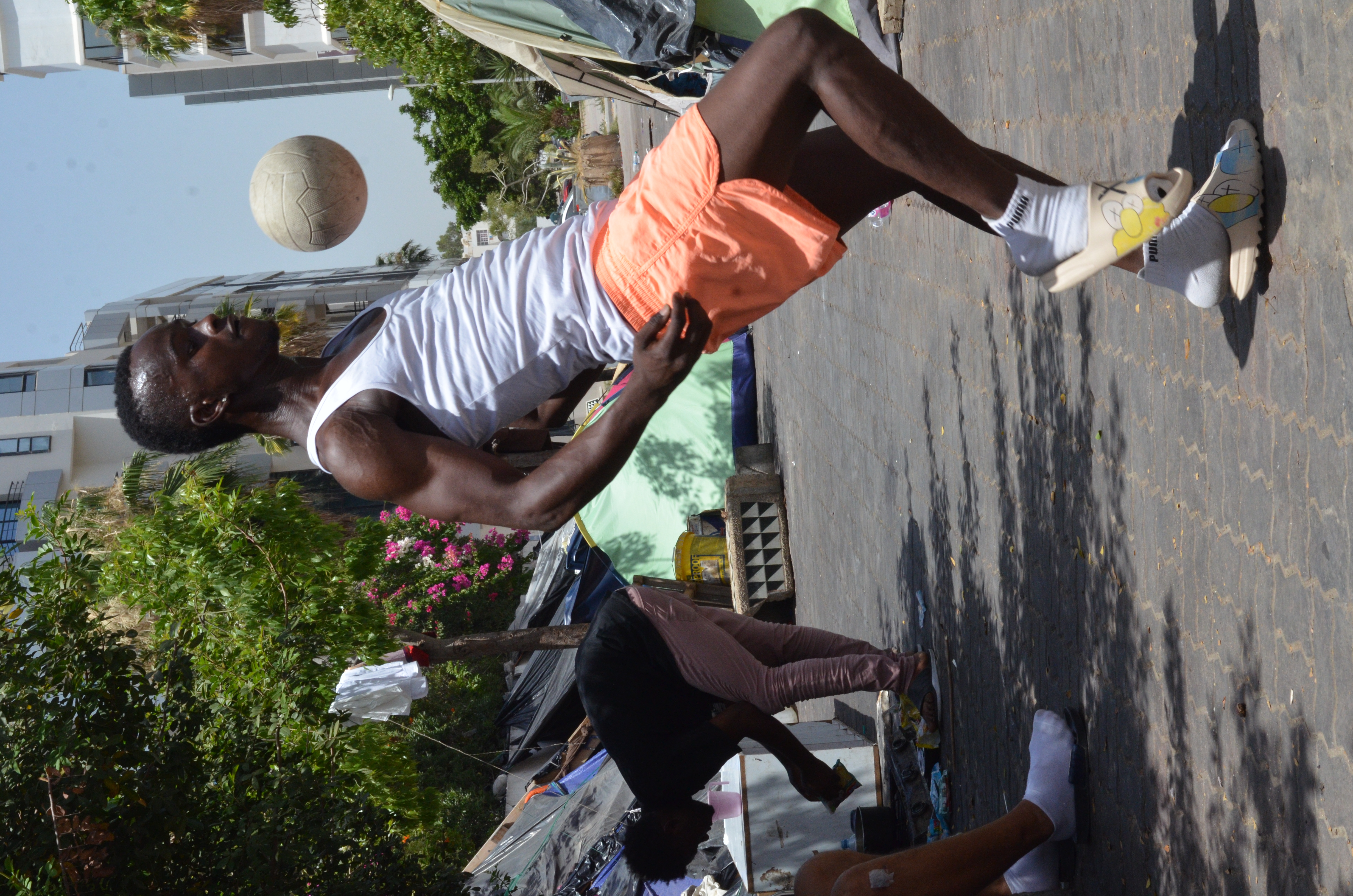 Ignoring the heat, Jalel, who used to be a professional footballer in Guinea, practices his skills with a child’s ball. His ambition is to play for a club in Europe