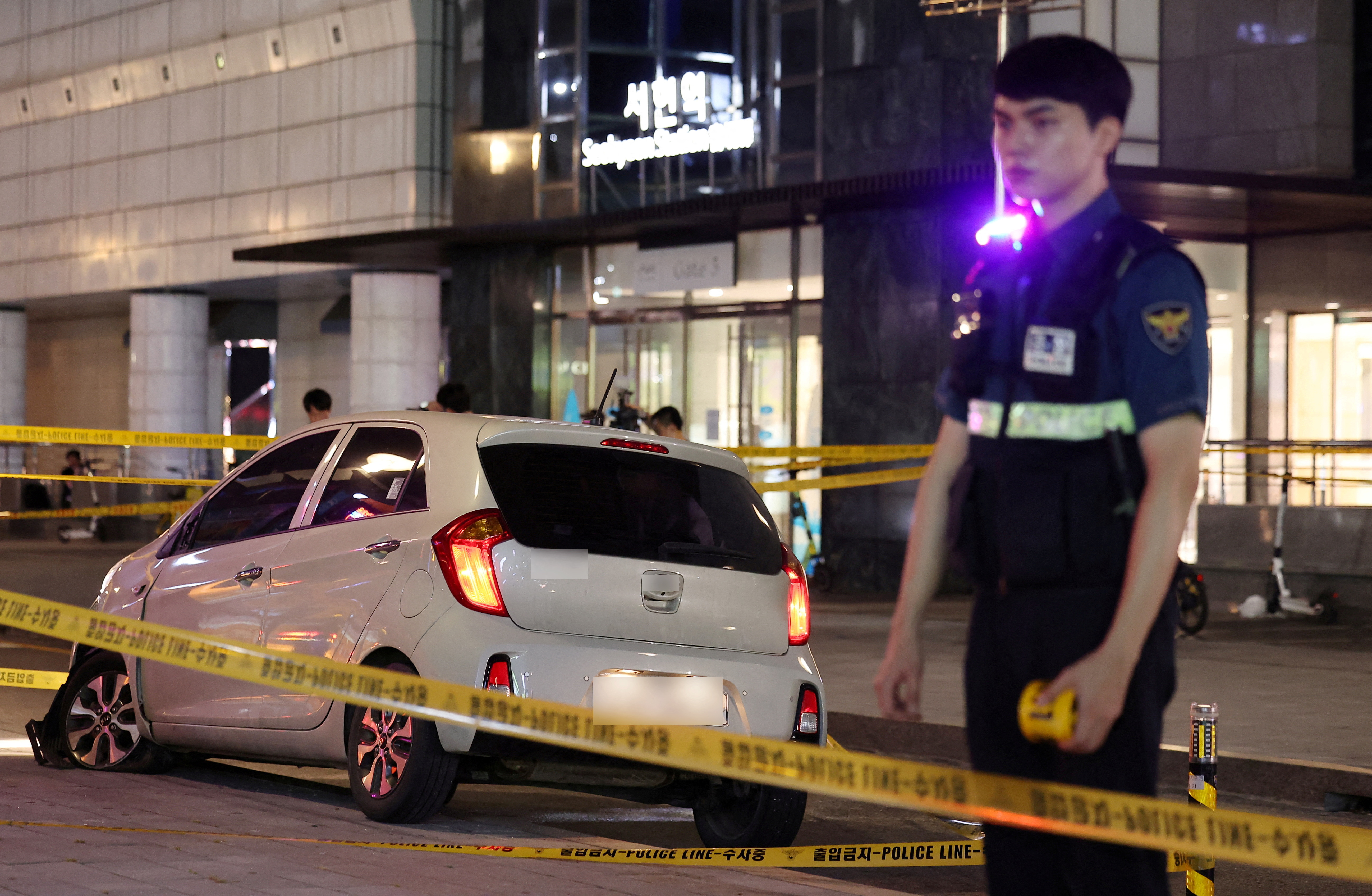 A policeman stands next to a scene where, according to media reports, nine people have been stabbed and four others hurt
